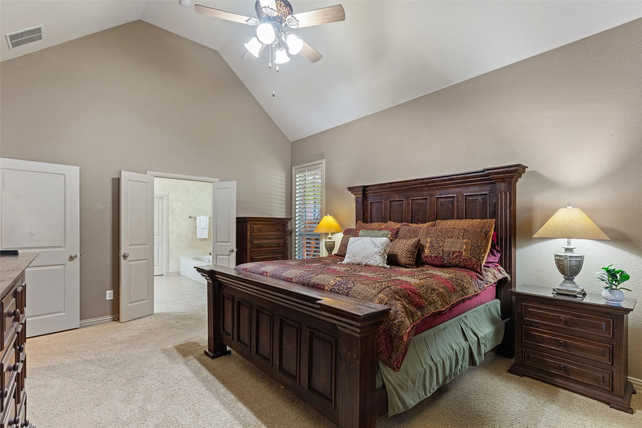 At day’s end, retreat to the spacious primary suite with its vaulted ceiling and private bath access.