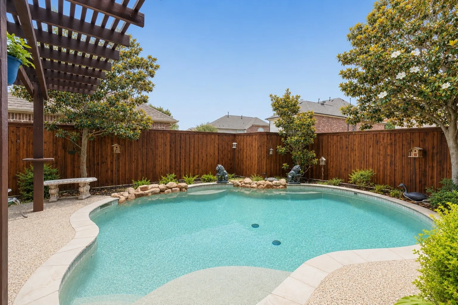 Surrounded by lush landscaping and custom stonework, the lagoon-style pool transforms the backyard into a peaceful escape designed for relaxing and entertaining alike.