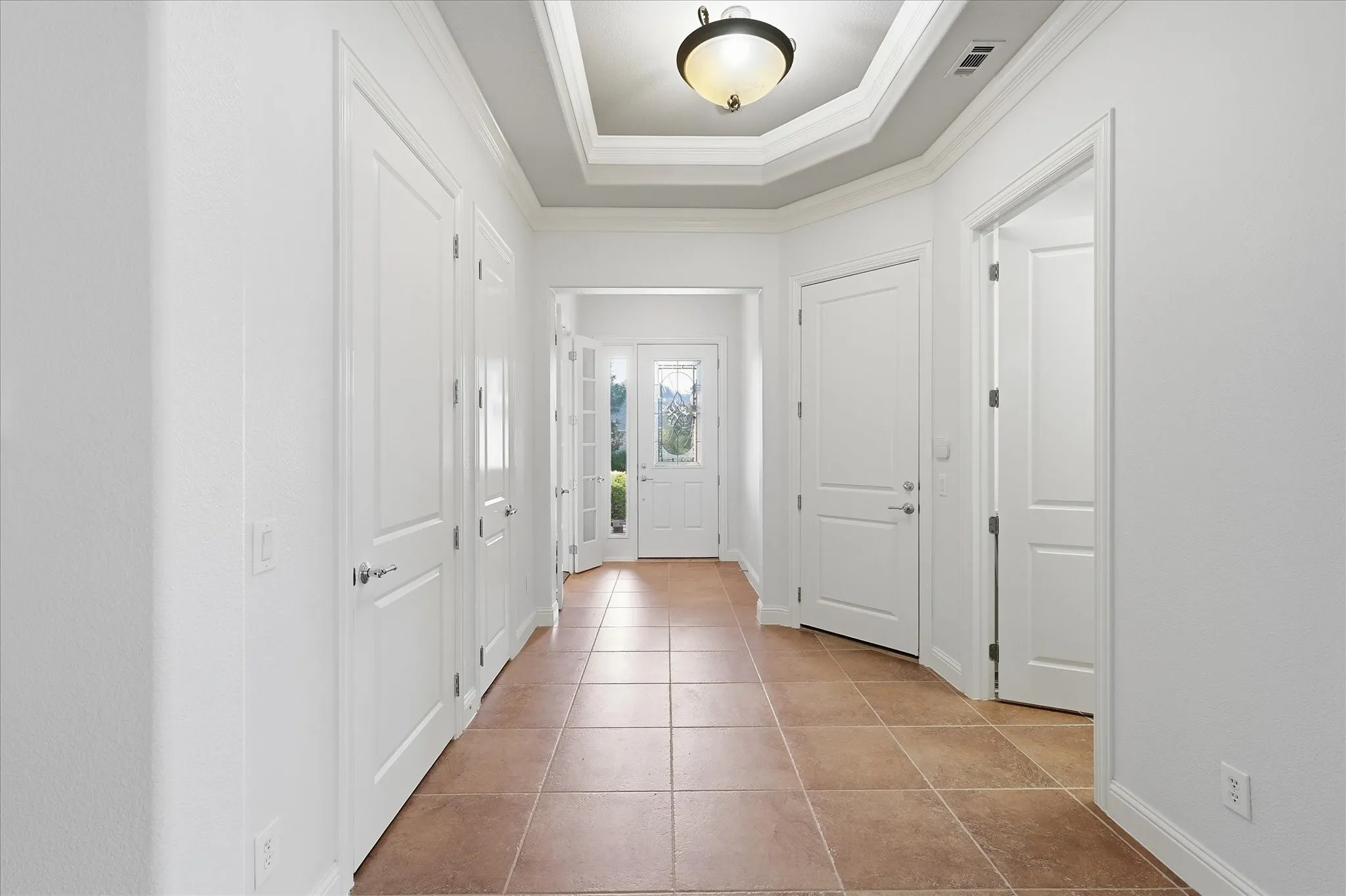 Welcoming open entryway with tray ceiling.
