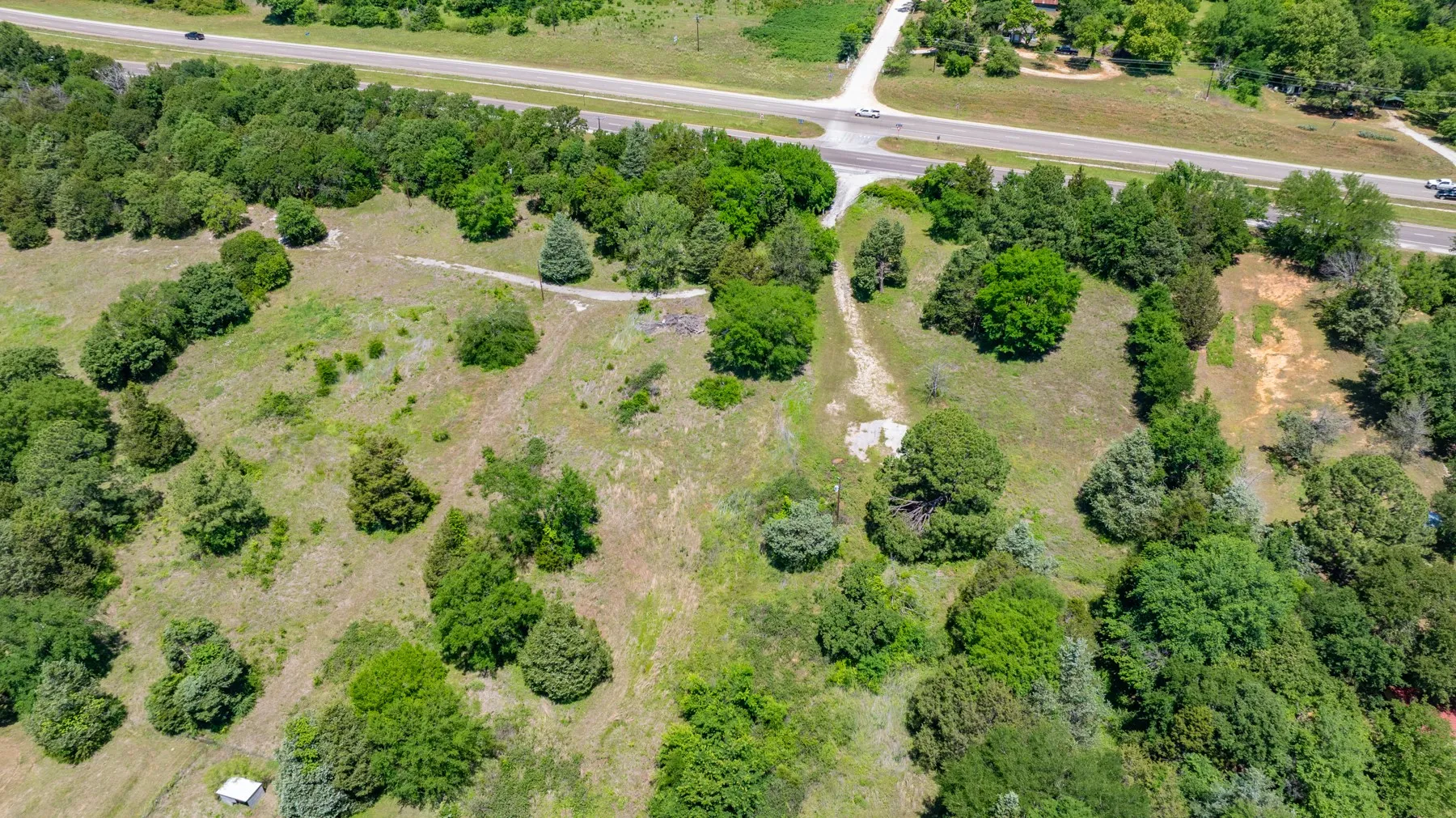 Expansive land parcel featuring a mix of mature trees and open grassy areas
