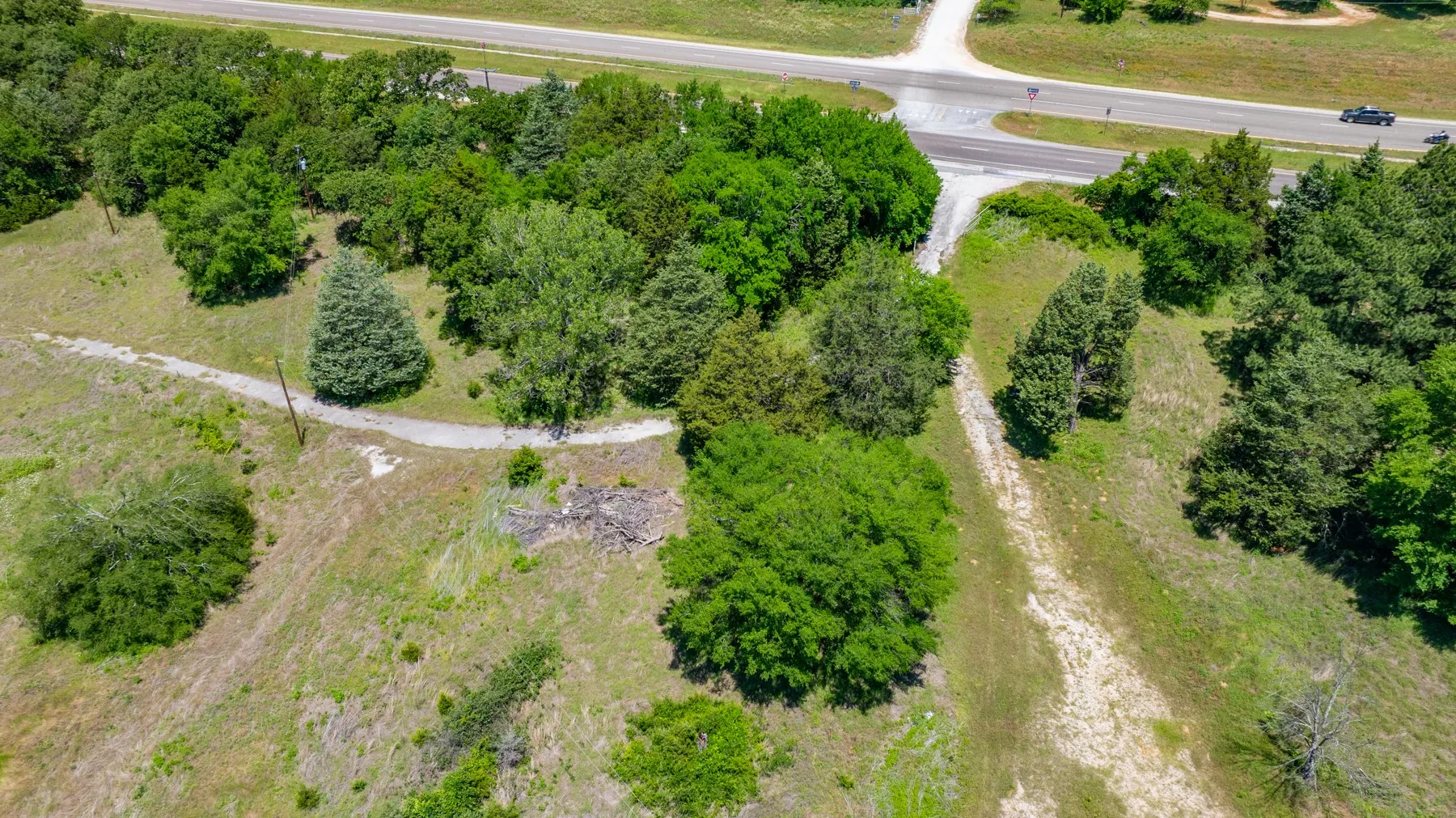 Heavily wooded lot featuring mature trees and a gravel pathway
