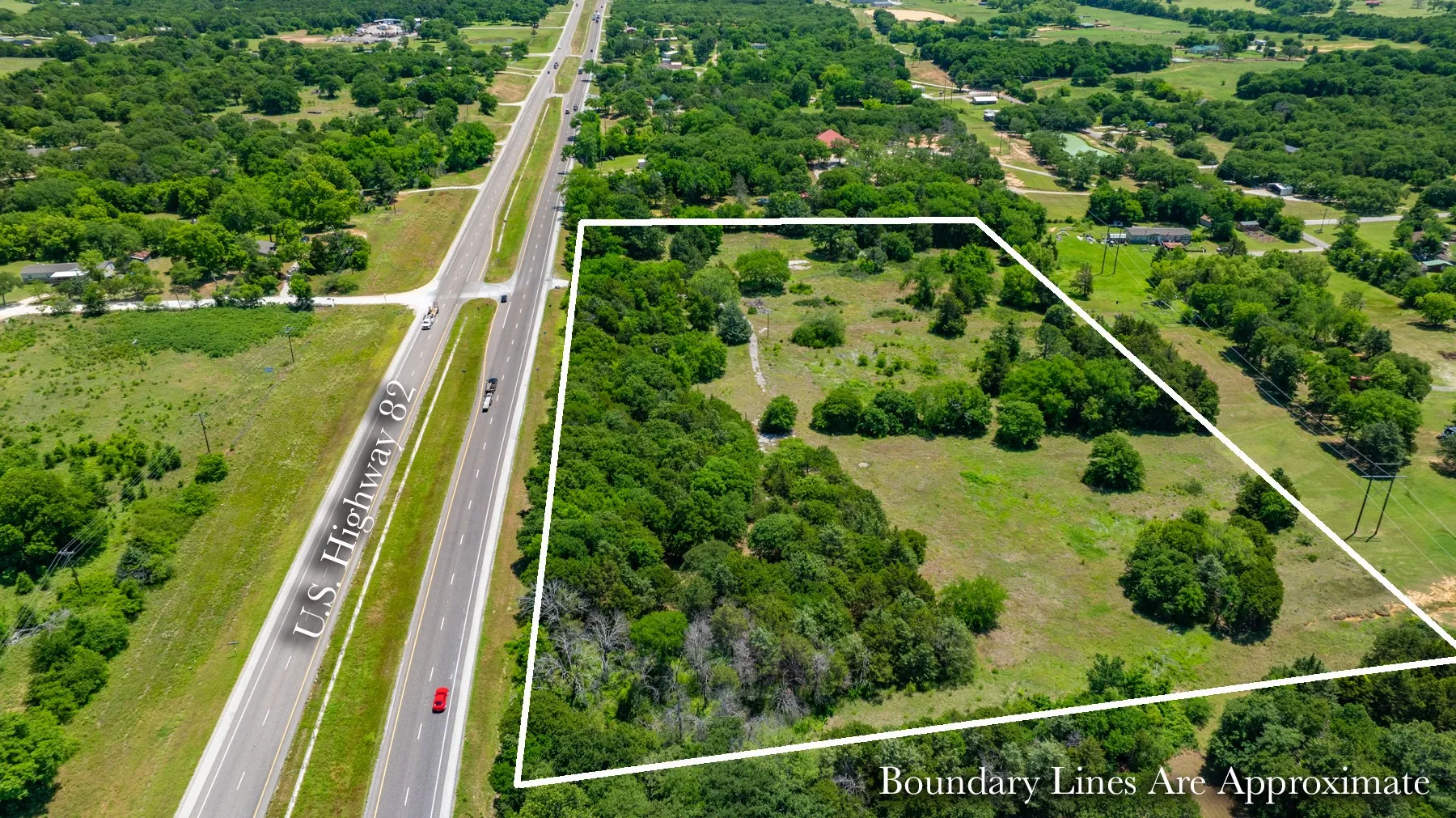 Expansive land parcel featuring a mix of open grassy areas and mature trees