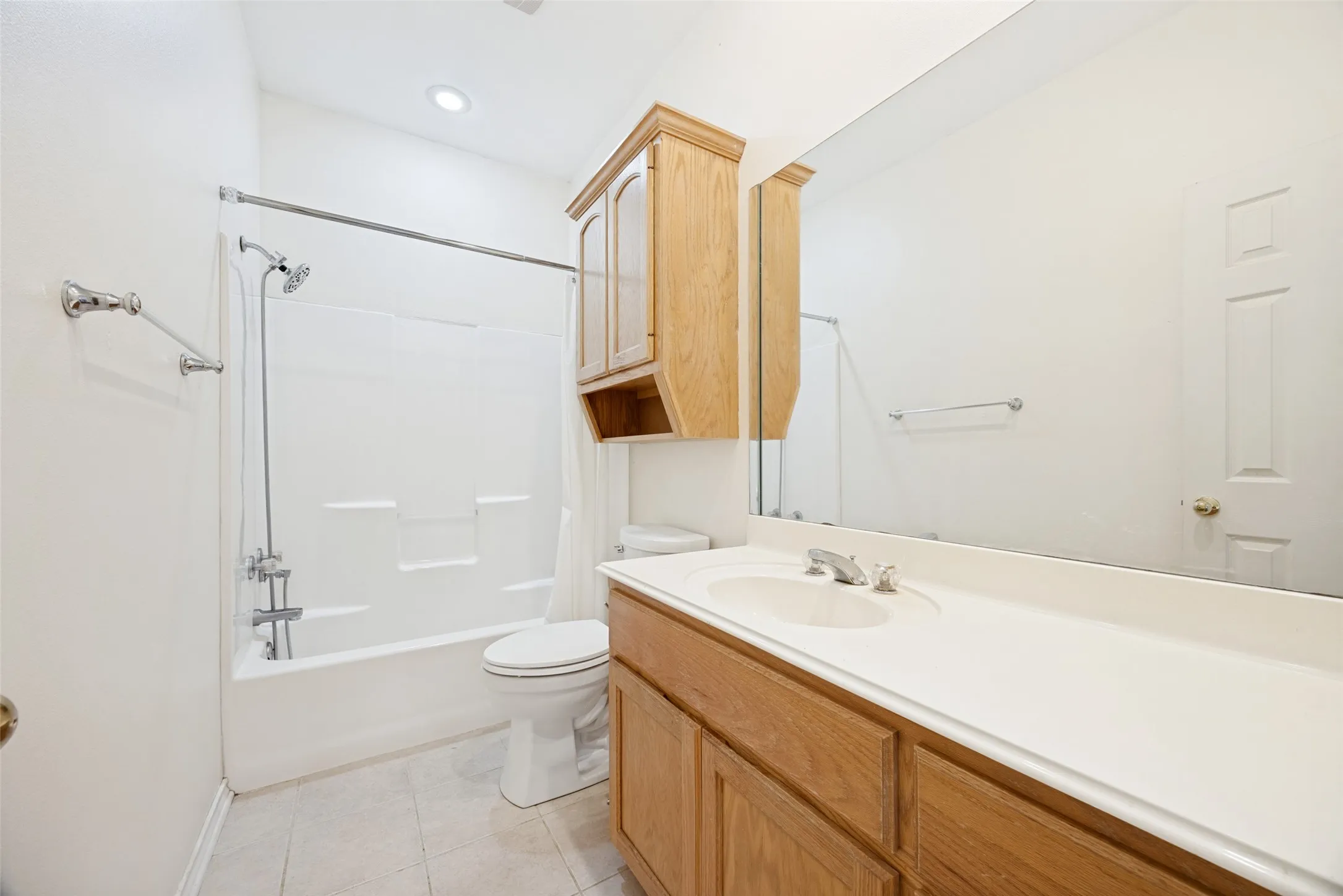 Full bathroom featuring a single vanity with wood-finish cabinetry, a white countertop, and an integrated sink