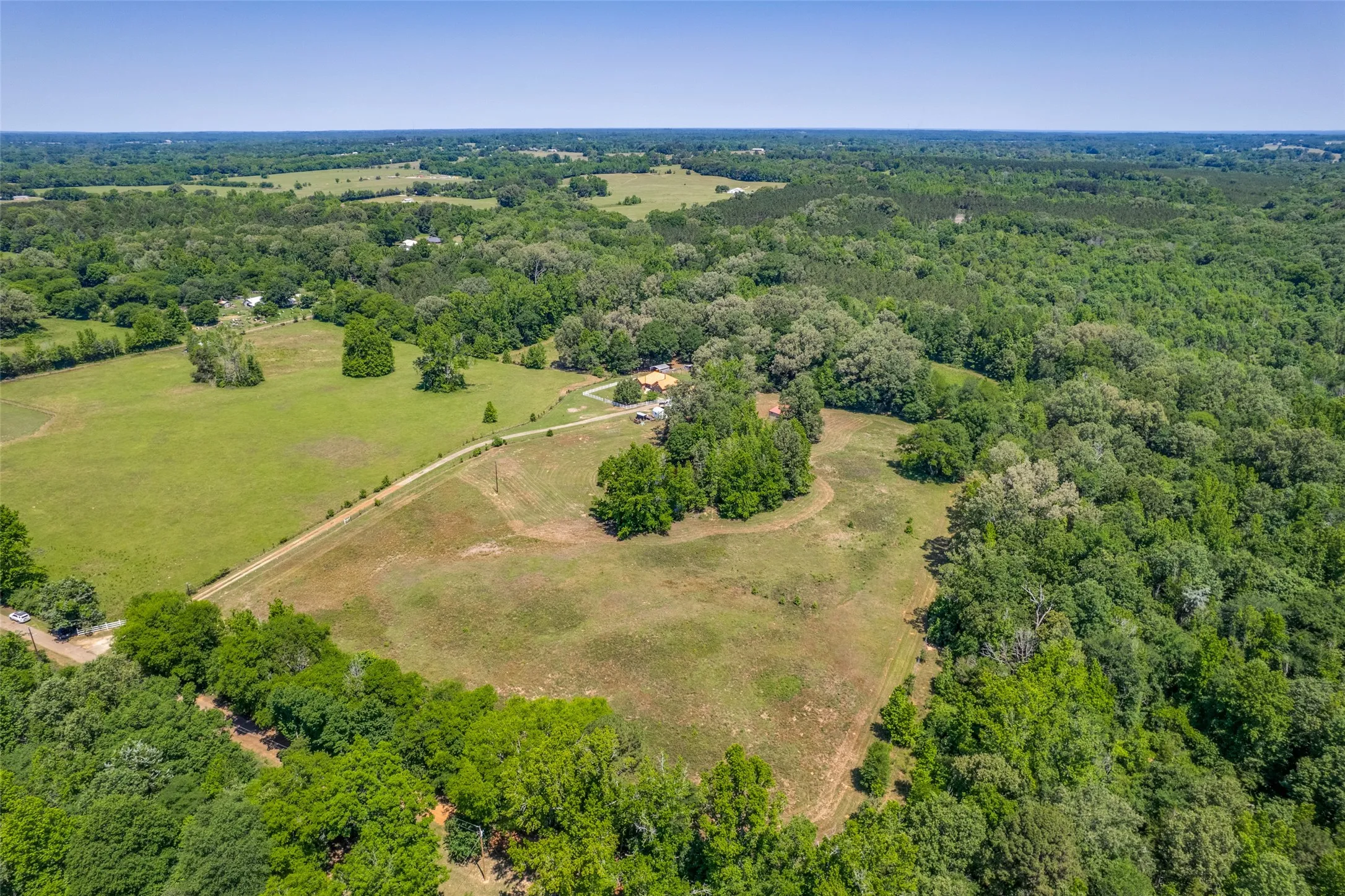 Expansive open fields surrounded by dense woodlands
