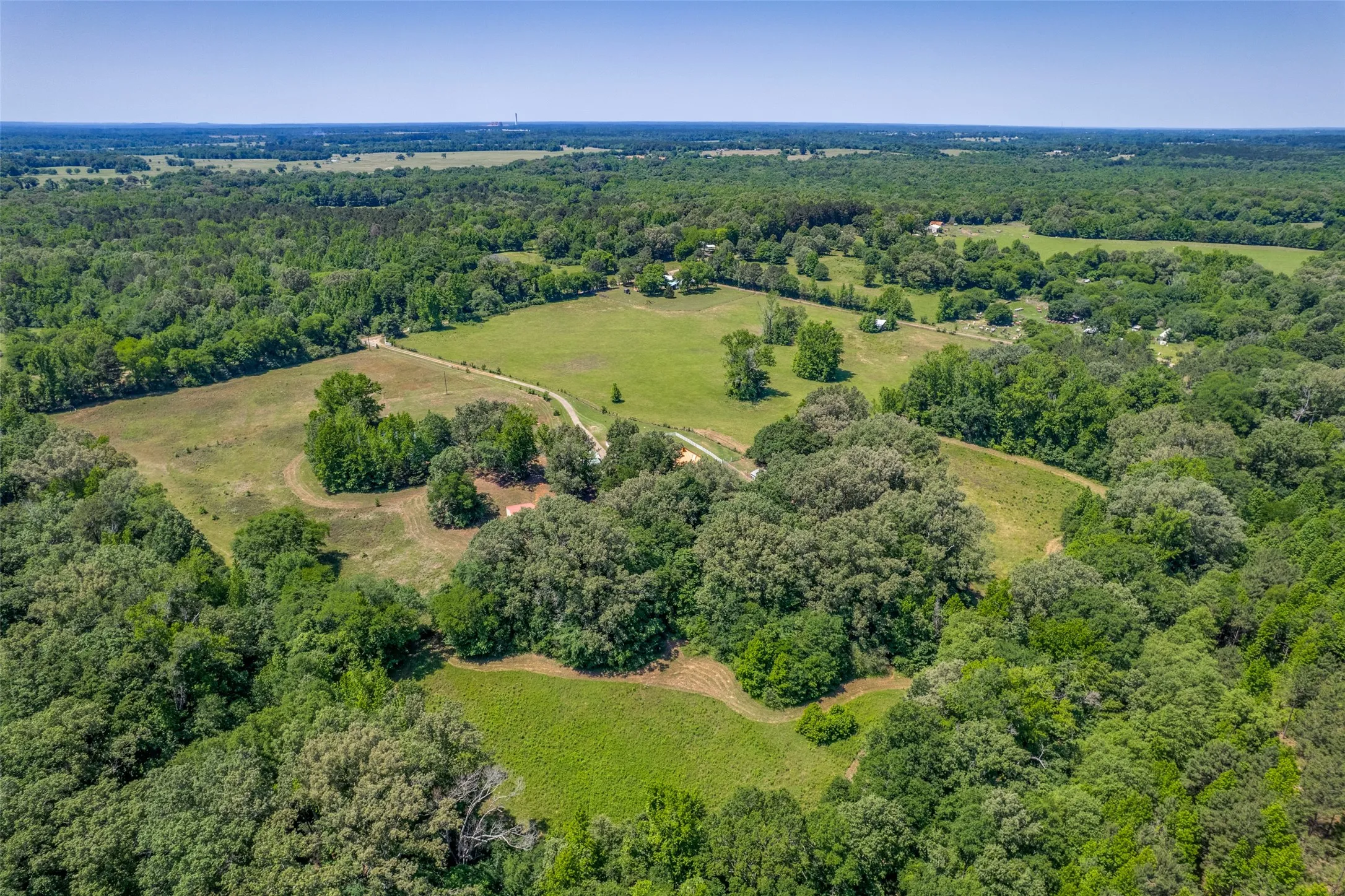 Expansive aerial property showcasing a blend of lush woodlands and open clearings