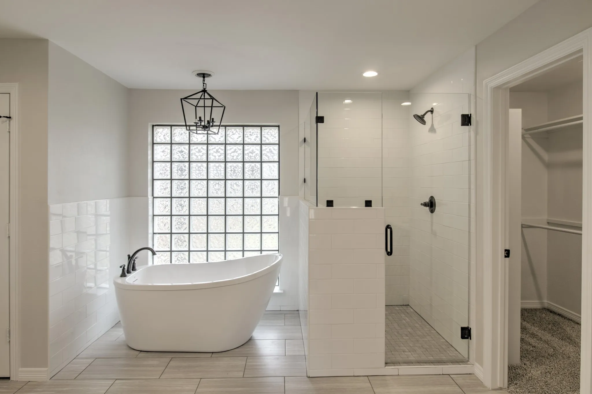 59" Free Standing Soaking Tub, a chandelier, separate walk in shower, with new custom glass enclosure.