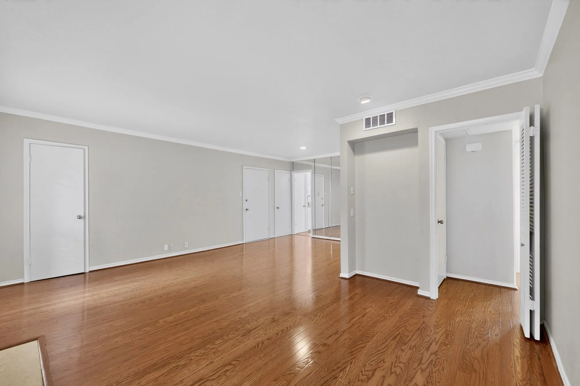 Spacious room featuring rich wood-finish flooring
