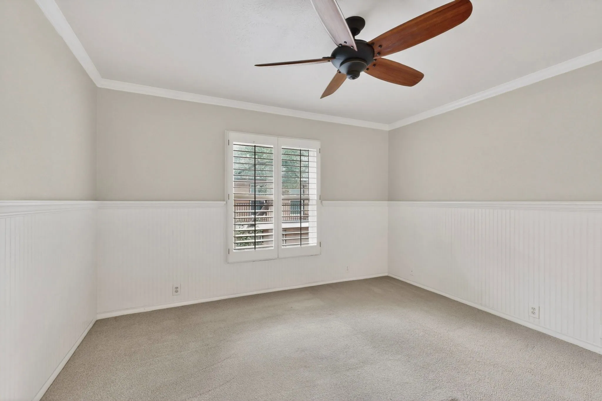 Neutral-toned room with white wainscoting and crown molding