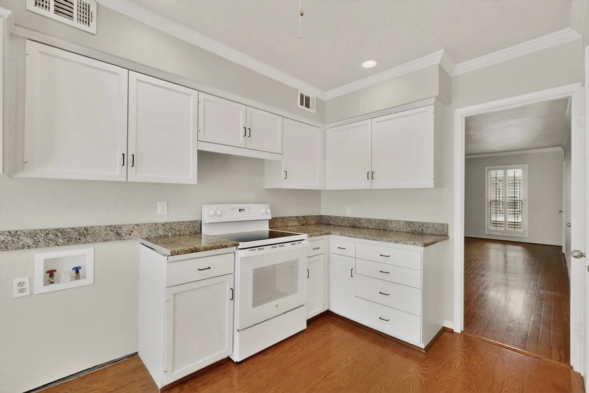 Kitchen featuring white cabinetry, stone-finish countertops, and an electric range