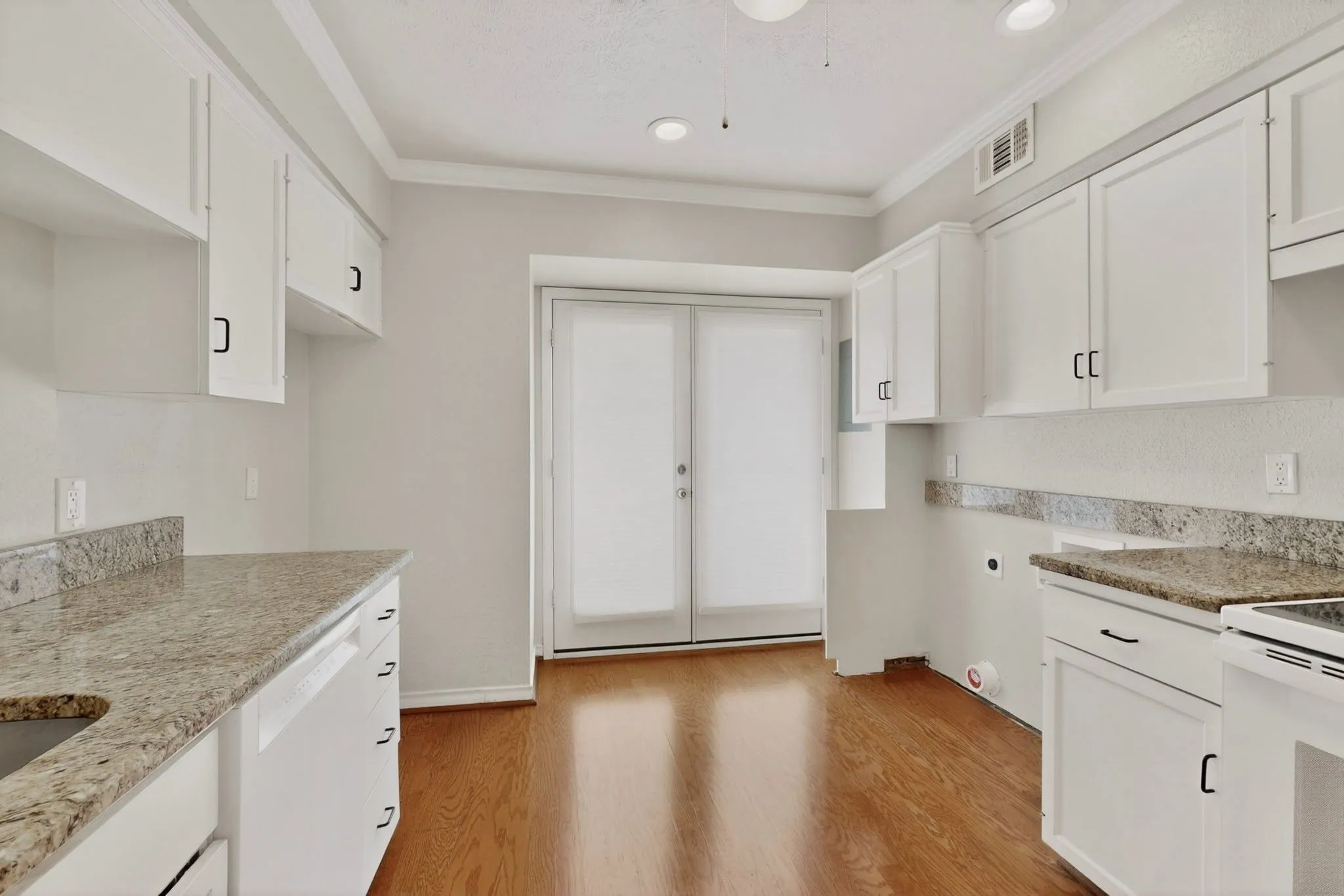 Kitchen featuring white cabinetry, granite countertops, wood-finish flooring, and recessed lighting