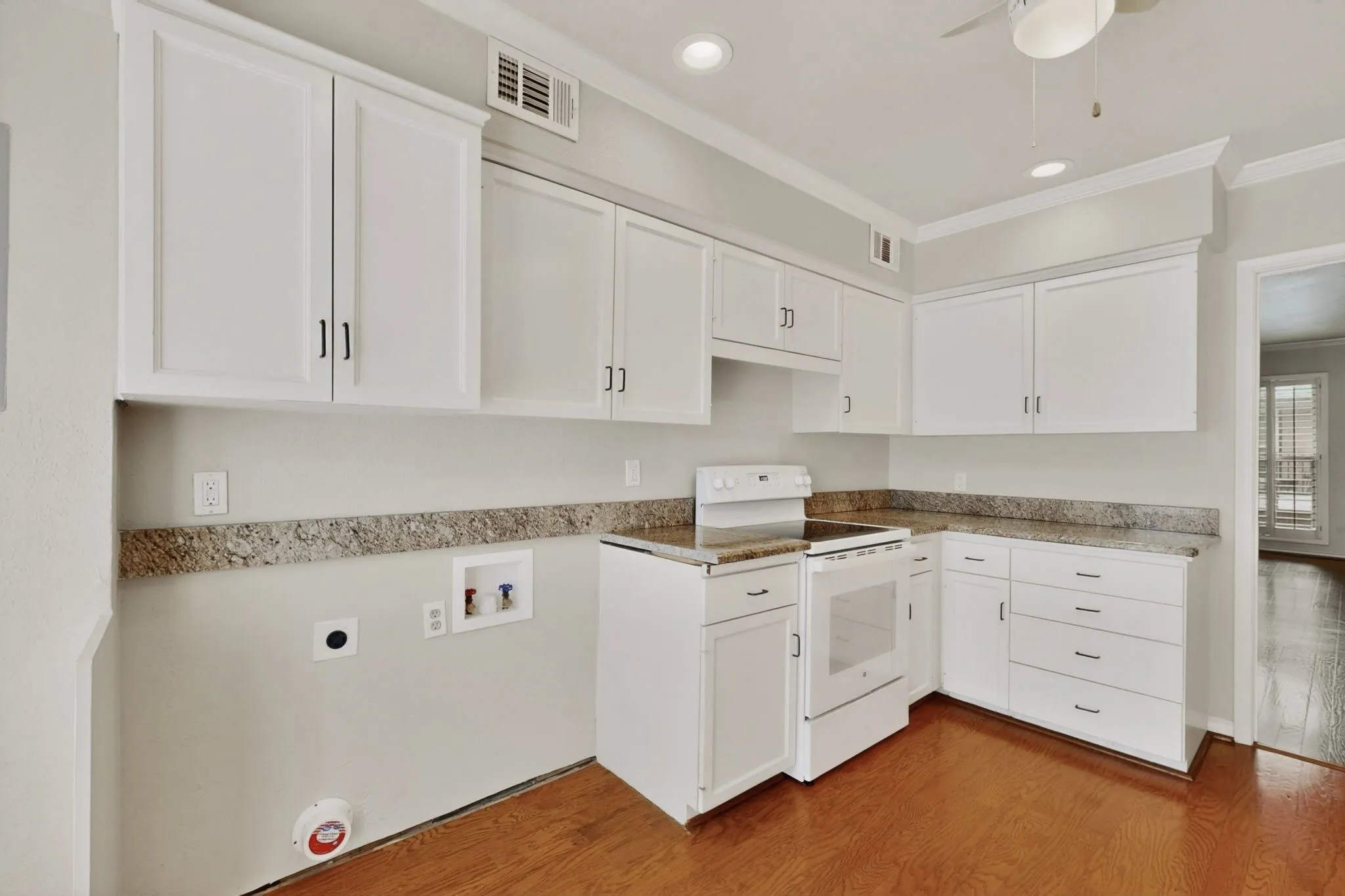 Kitchen featuring white cabinetry, granite-finish countertops, and wood-finish flooring