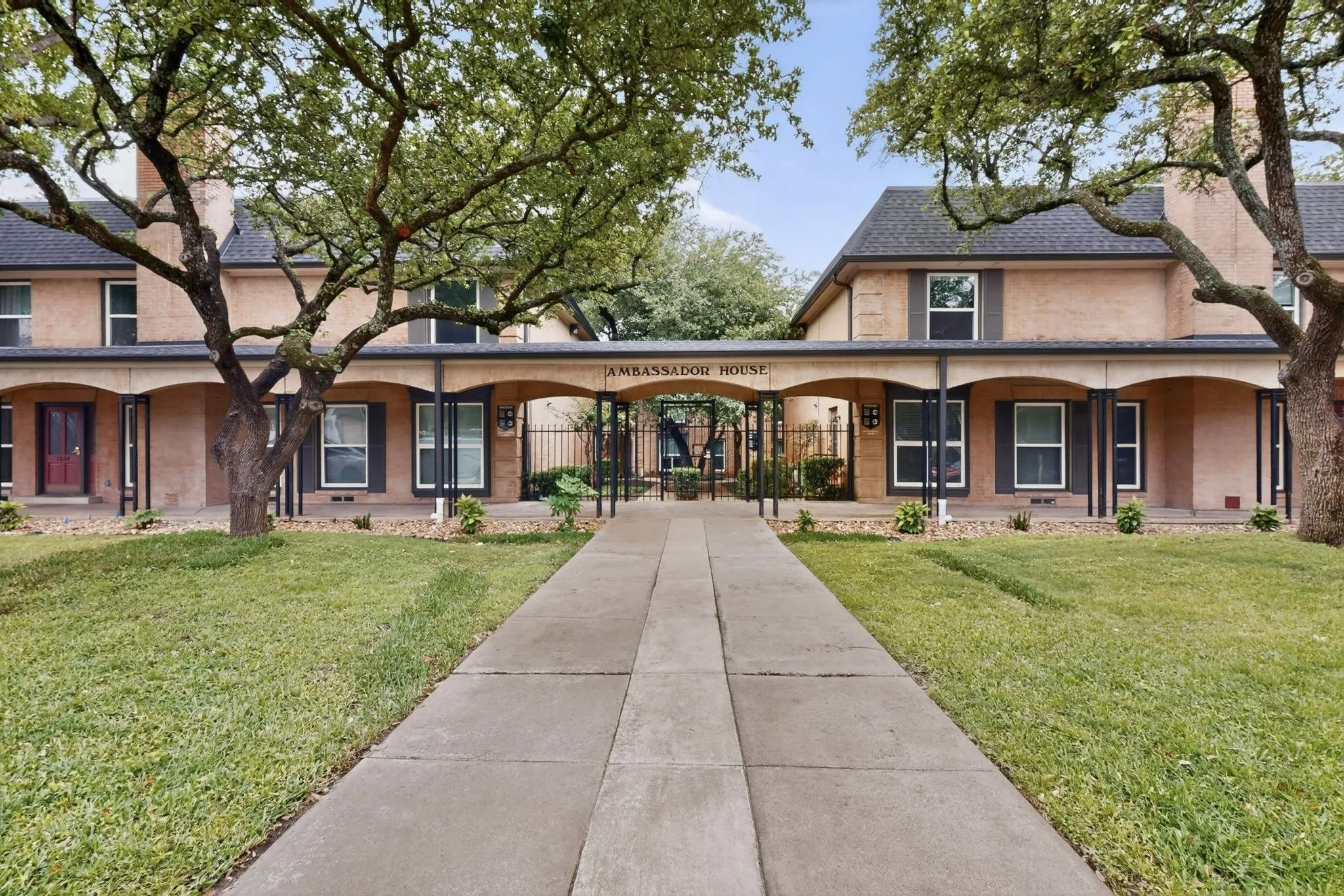Symmetrical facade with stucco exterior and pitched shingle roof