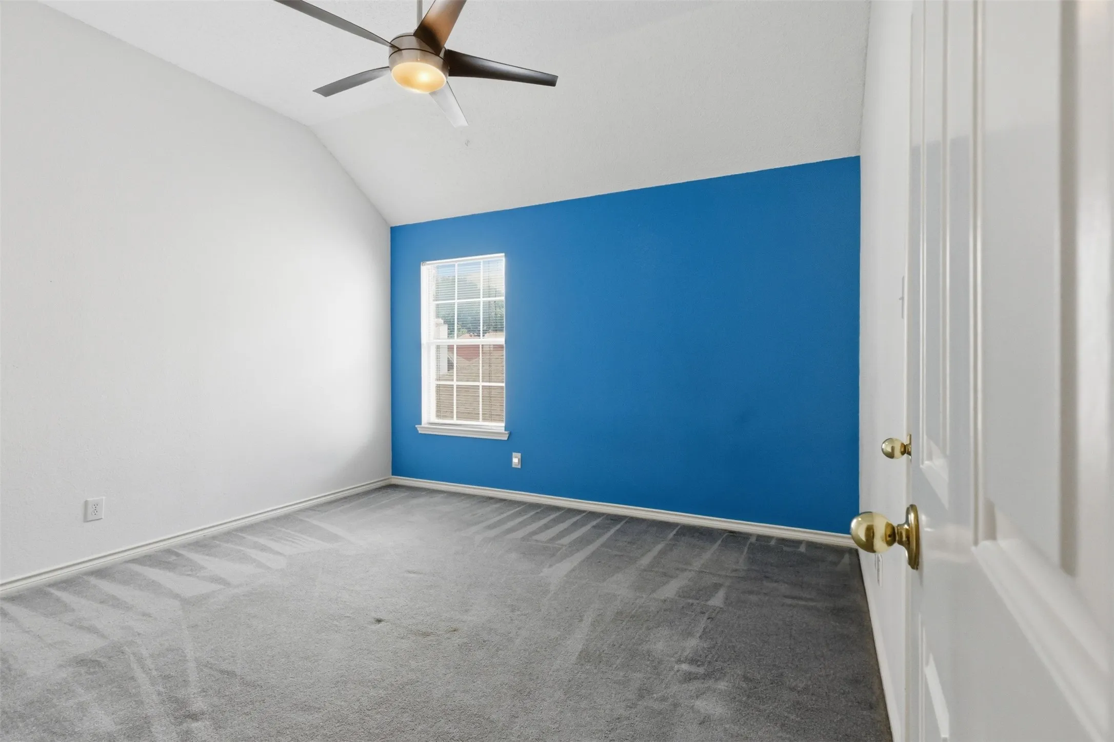 Room featuring a vaulted ceiling and a ceiling fan with integrated lighting