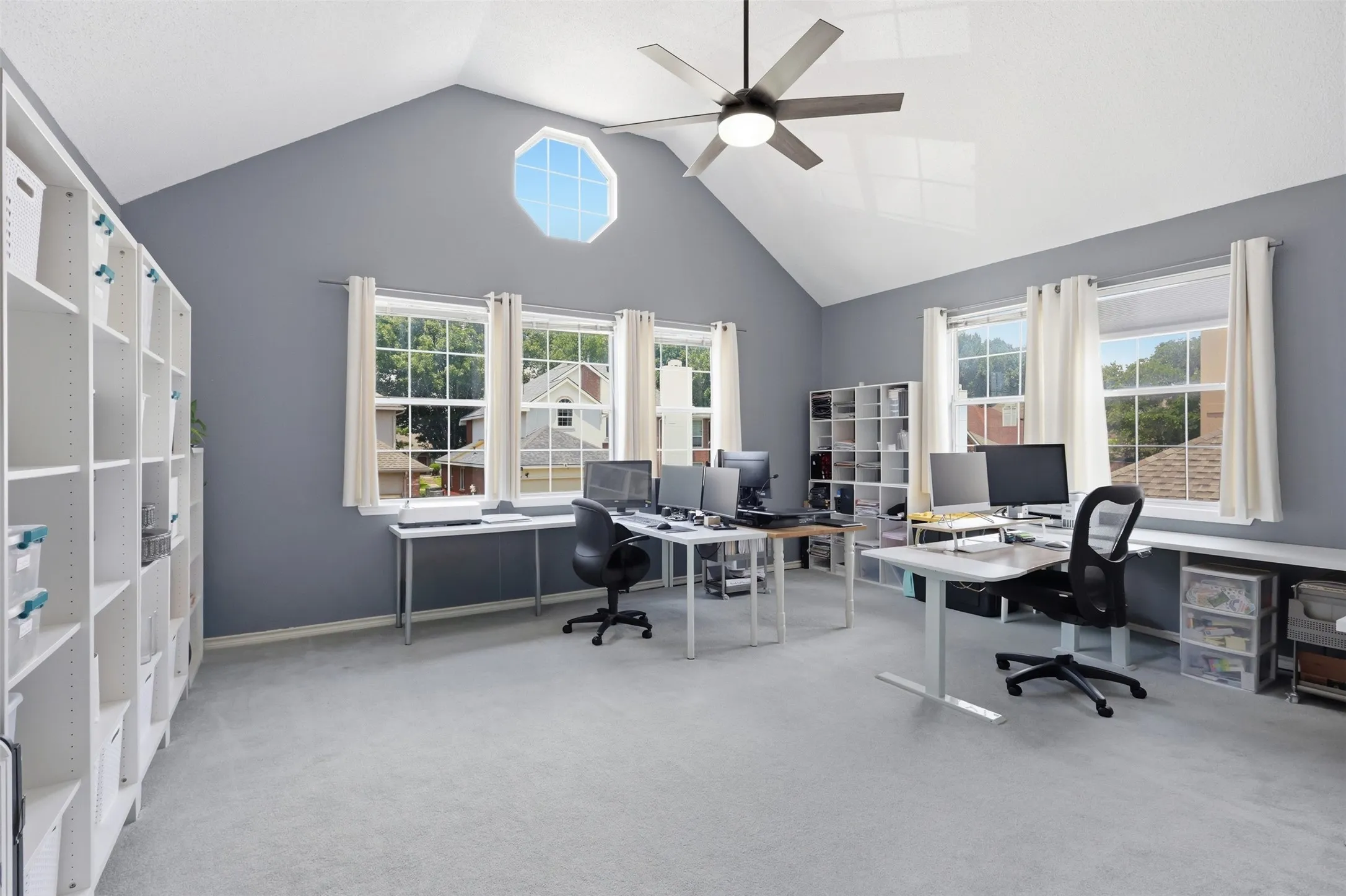 Vaulted ceiling with an octagonal window and ceiling fan