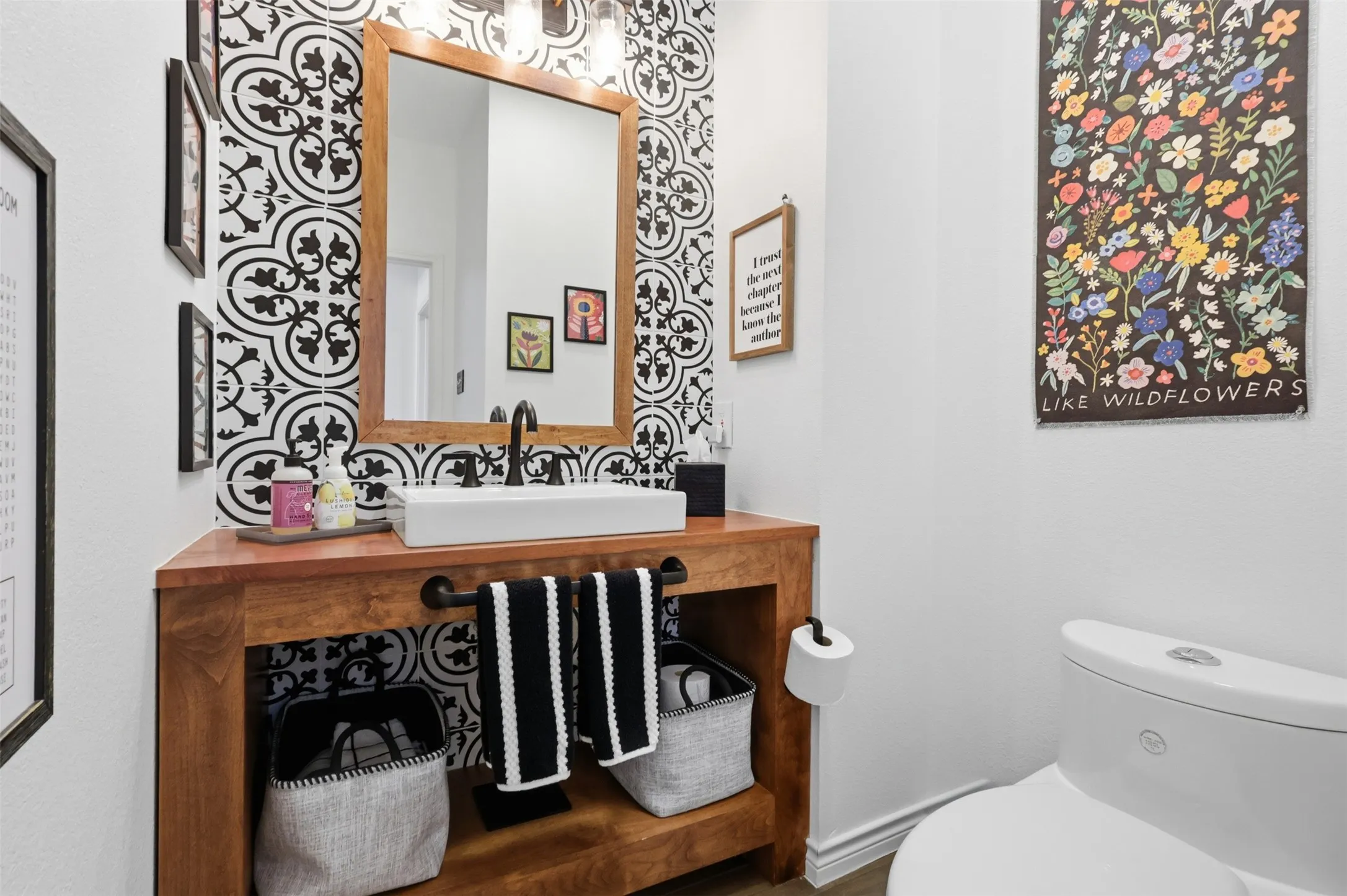 Wood-finish vanity with an open lower shelf, featuring a rectangular vessel sink and a matte black faucet