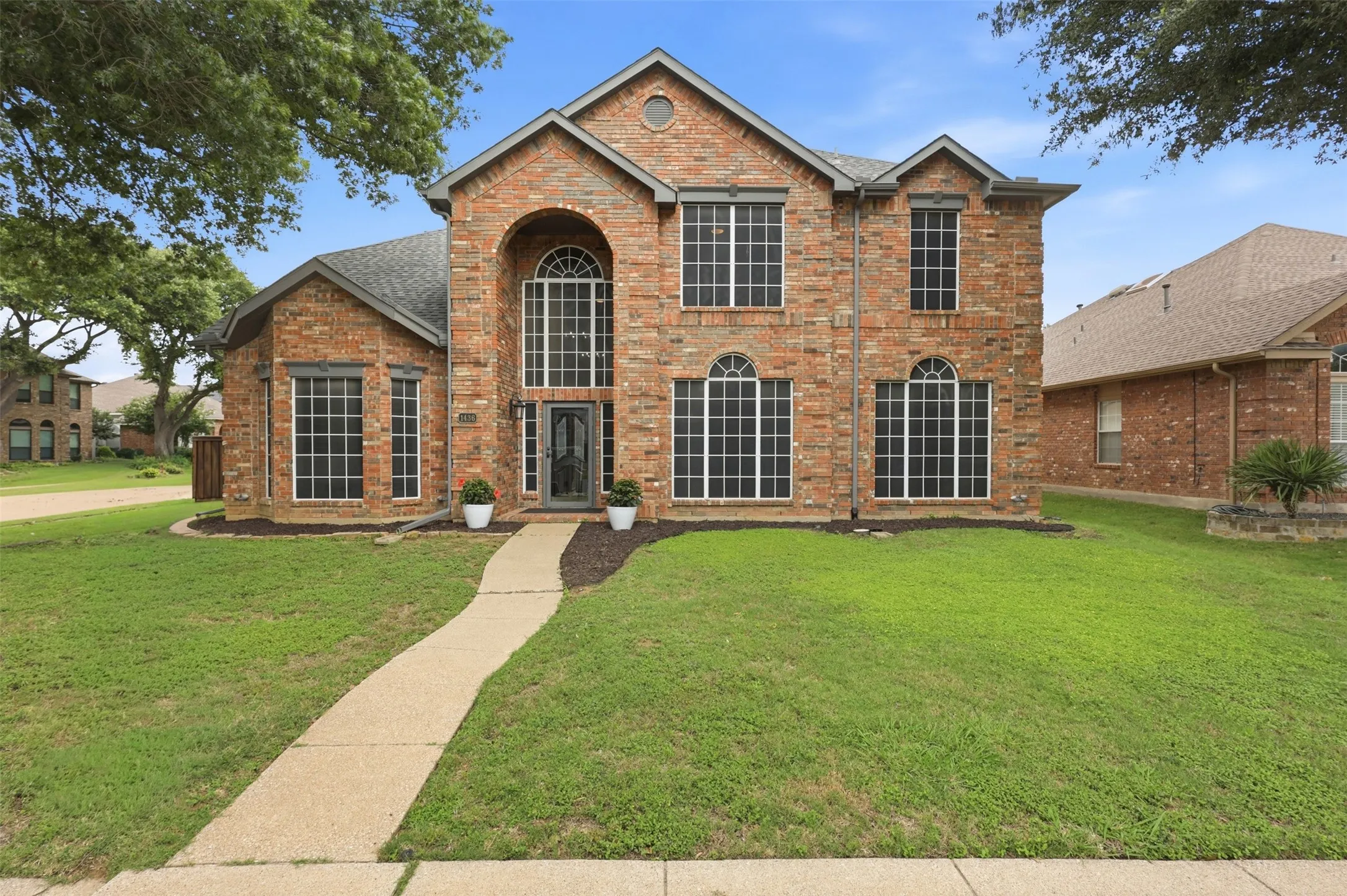 Brick exterior with an arched entryway and dark-frame windows