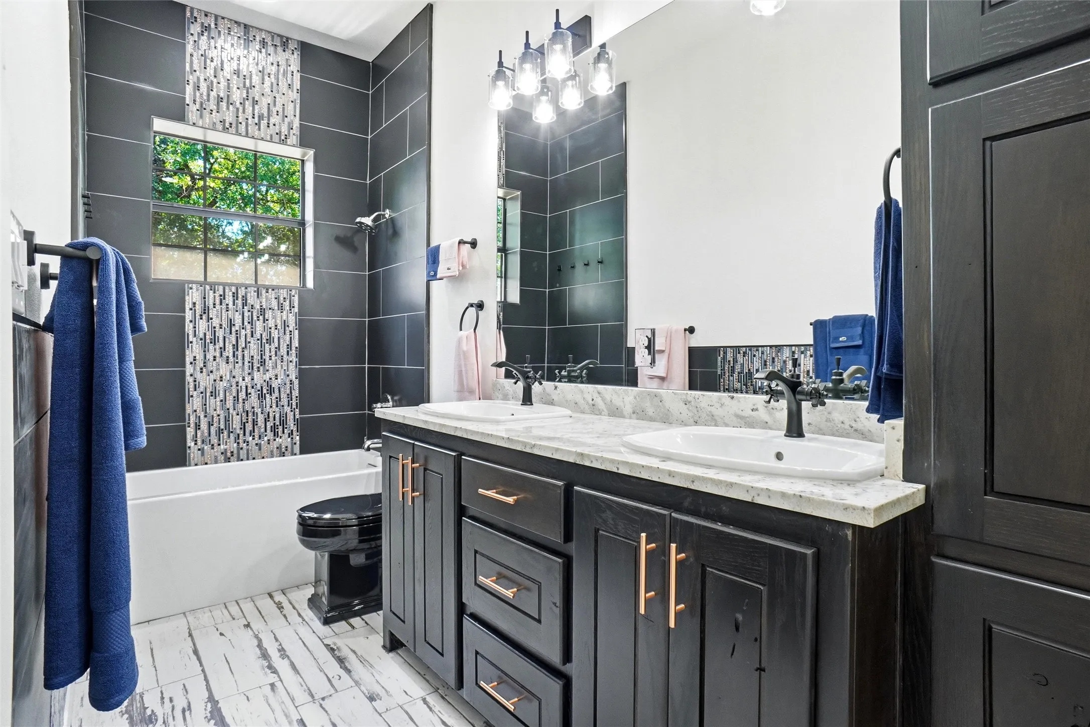 Secondary bath with dual sinks and beautiful tilework.