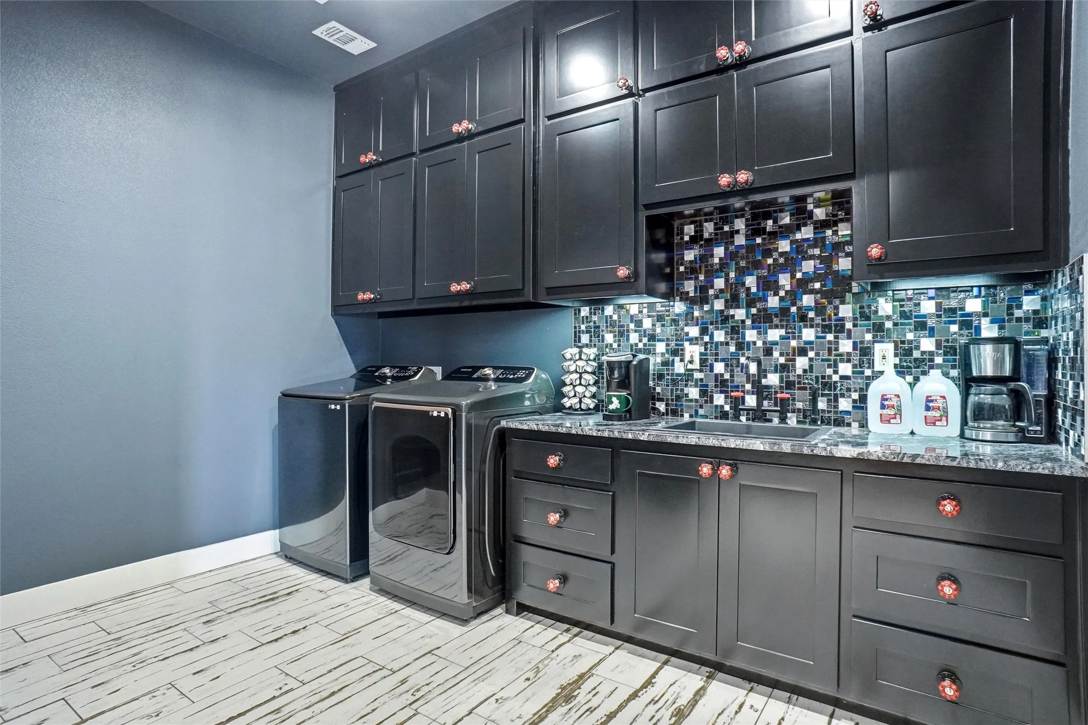 Another view of kitchen with washer and dryer. Check the unique cabinet hardware!
