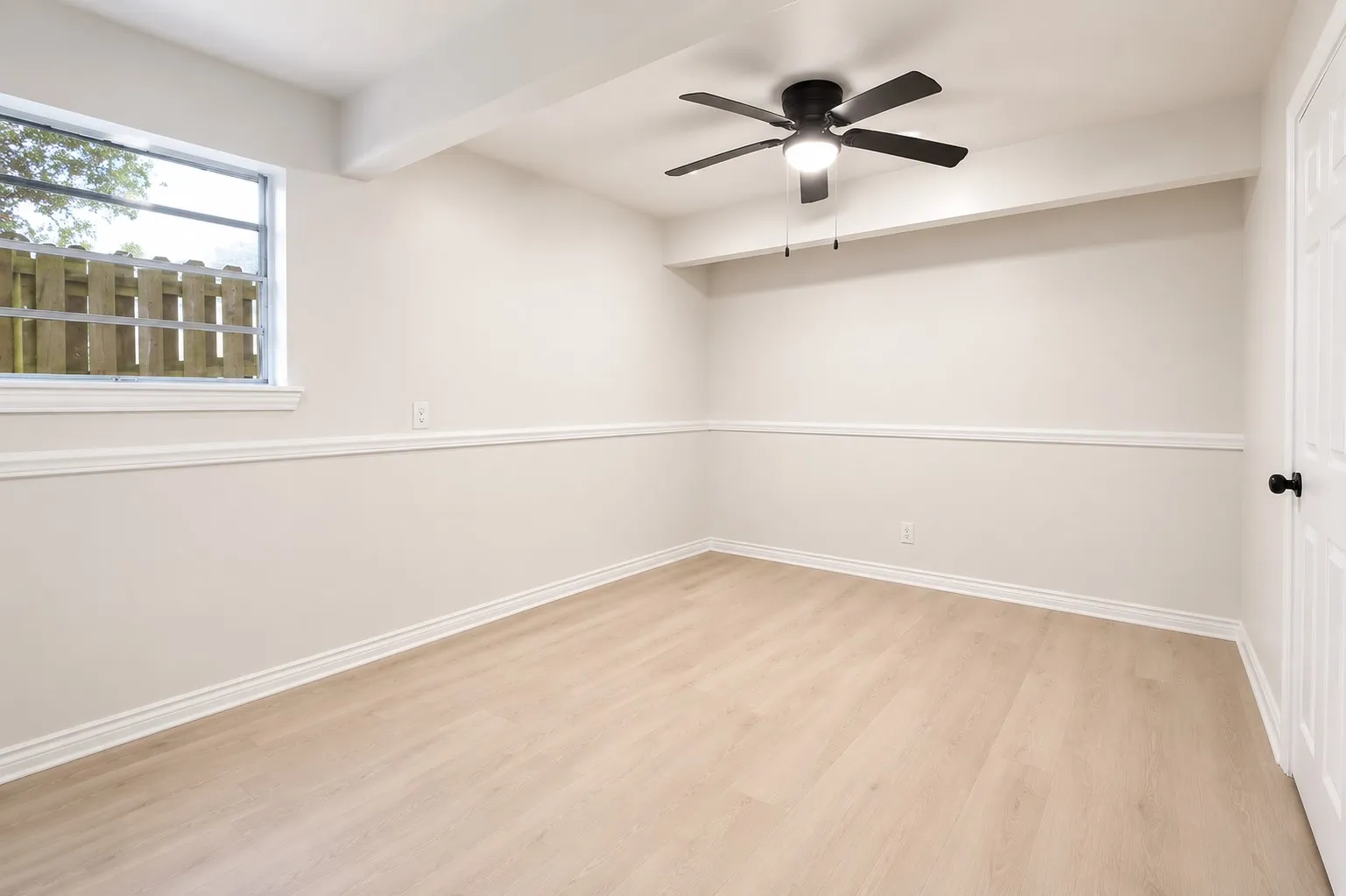 2nd Level - 4th Bedroom featuring light wood-finish flooring, a contemporary ceiling fan, baseboard molding, chair rail molding, and a white paneled door with matte black hardware