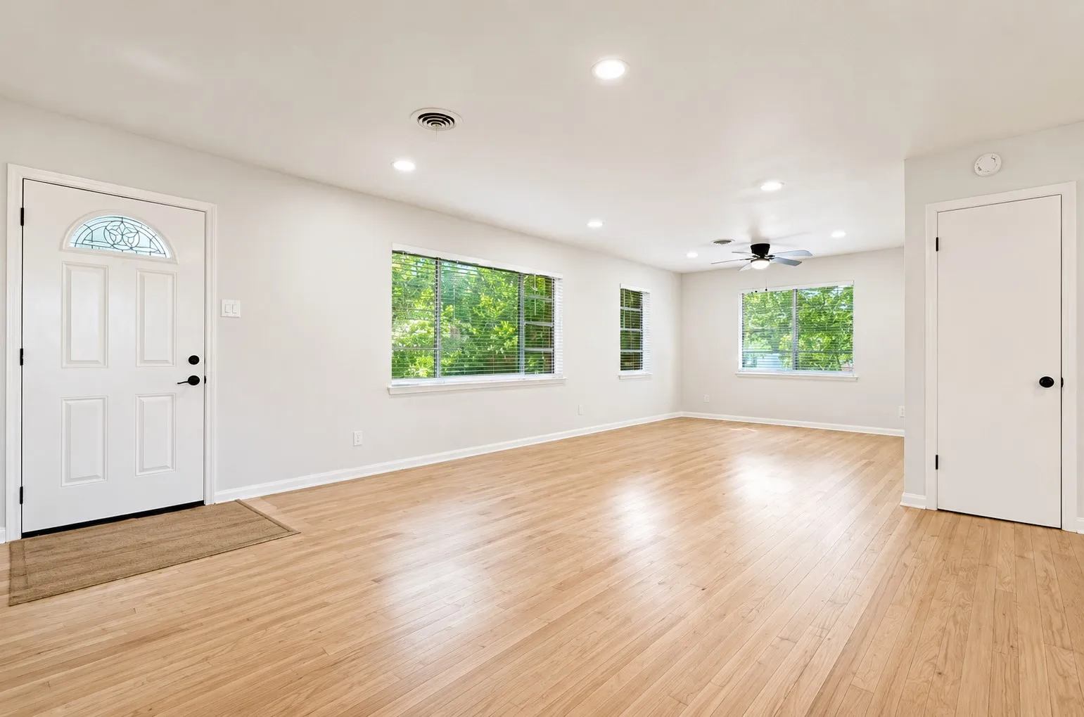 1st Level - living room expansive living space featuring wood-finish flooring, recessed lighting, multiple windows, and a ceiling fan