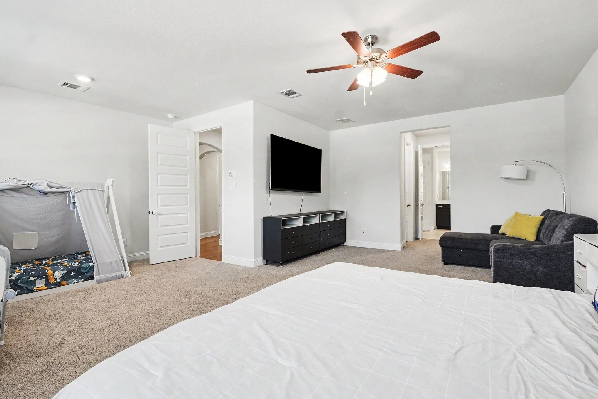 Spacious interior room featuring light-toned carpet flooring and white walls