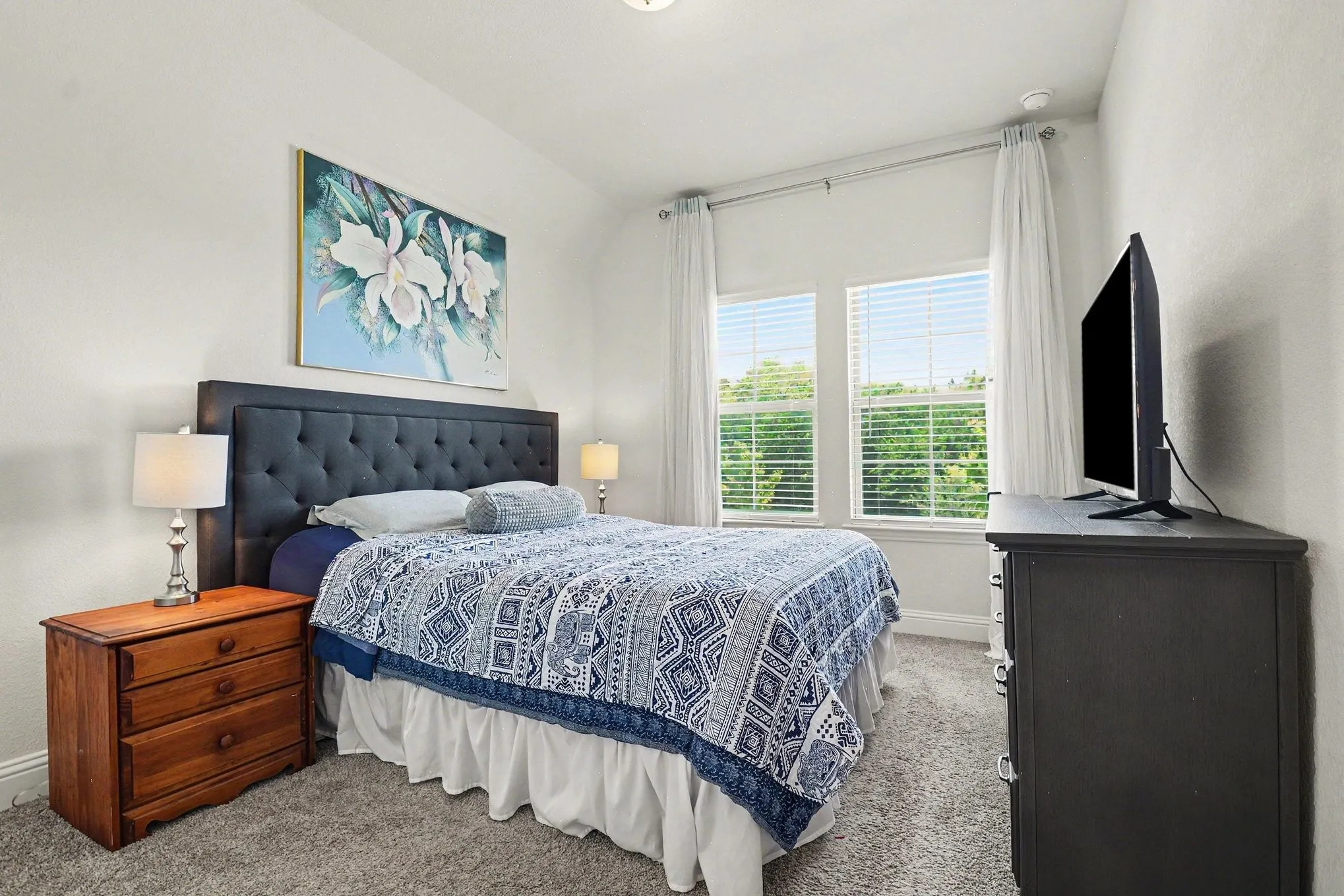 Bedroom featuring a tufted upholstered headboard, dual windows with blinds, recessed lighting, and carpet flooring