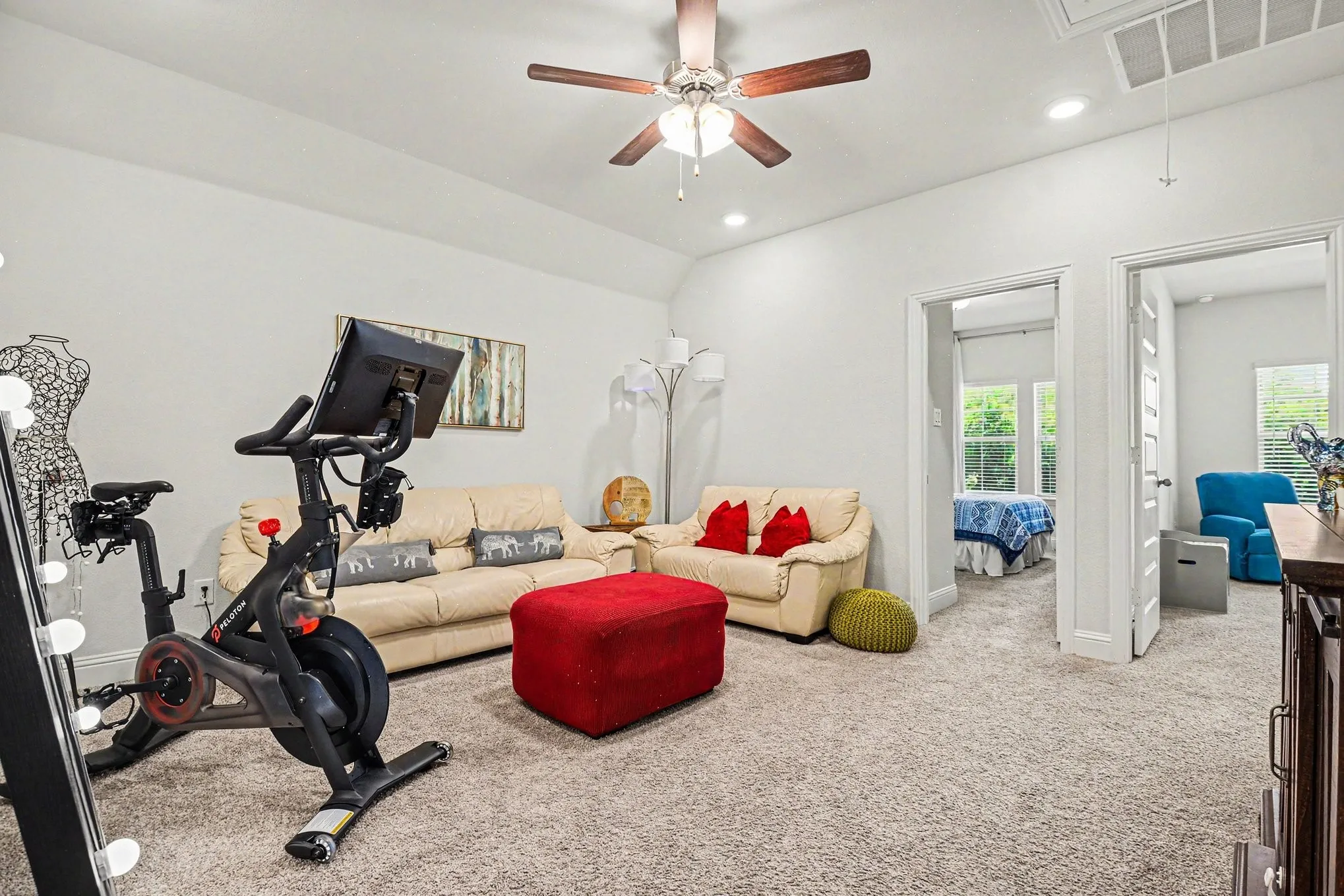 Spacious carpeted room featuring vaulted ceilings, recessed lighting, and a ceiling fan