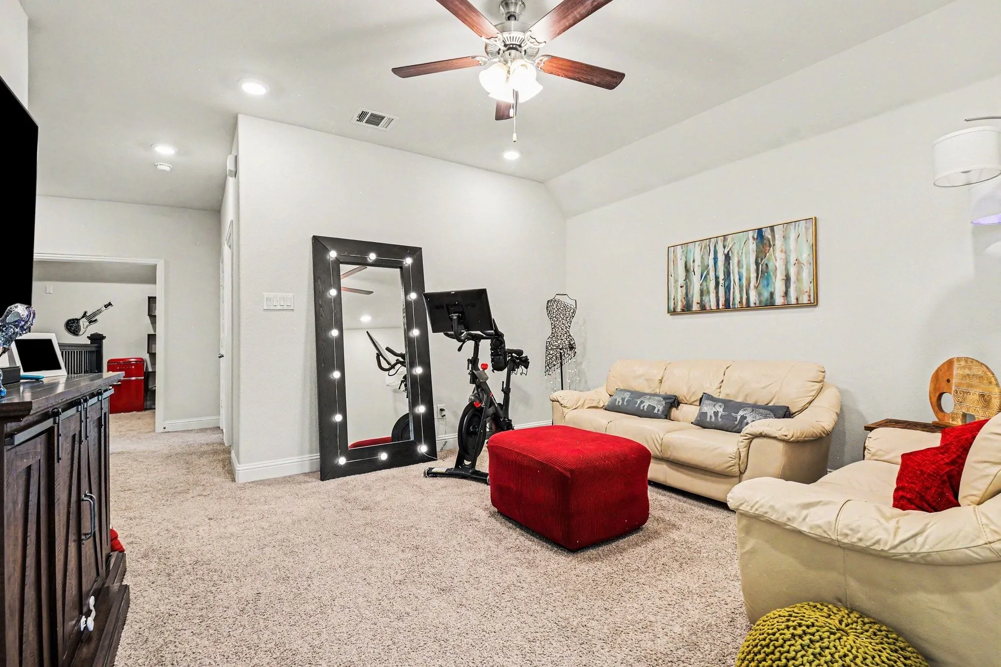 Spacious room featuring vaulted ceilings, recessed lighting, and soft carpet flooring