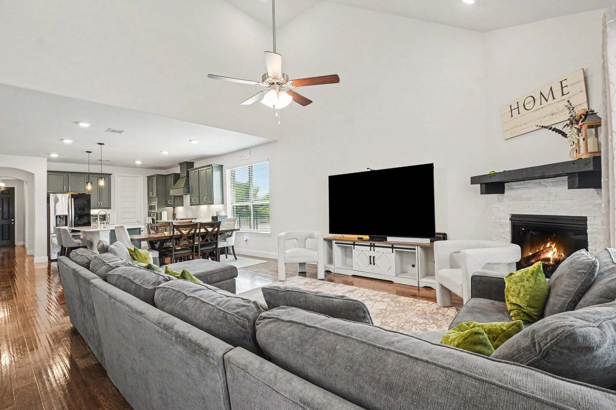 Vaulted ceiling living area featuring wood-finish flooring and an open-concept design