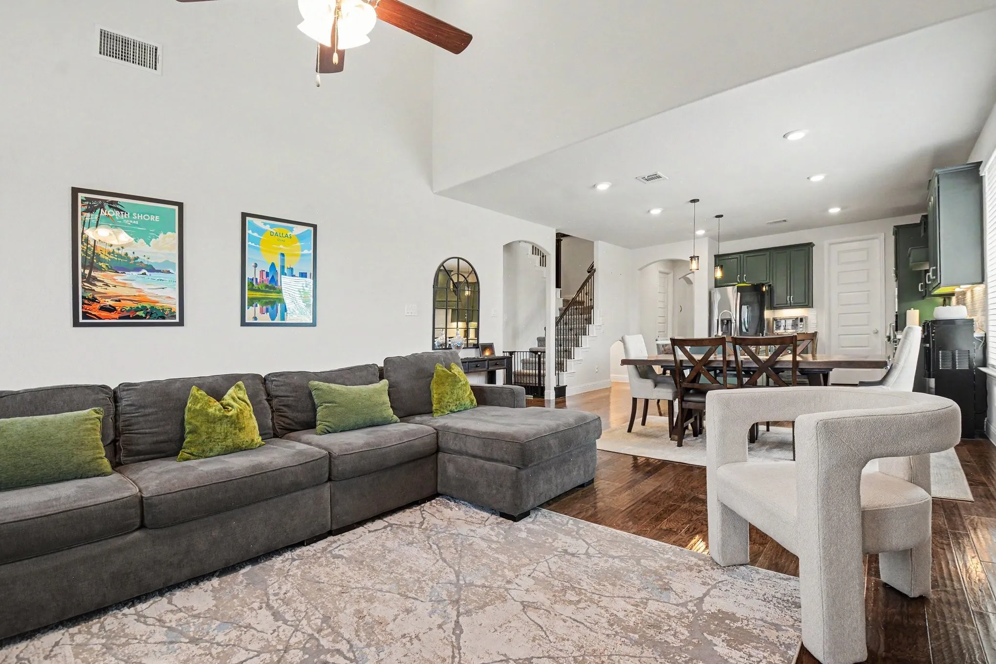Open-concept living space featuring high ceilings, wood-finish flooring, a ceiling fan, and recessed lighting