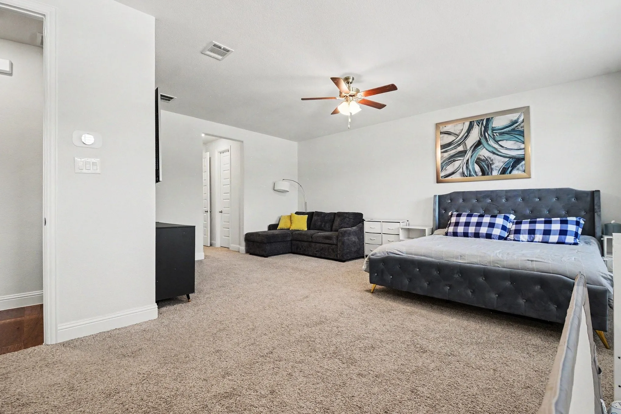 Spacious room featuring neutral carpet flooring, recessed lighting, and a ceiling fan
