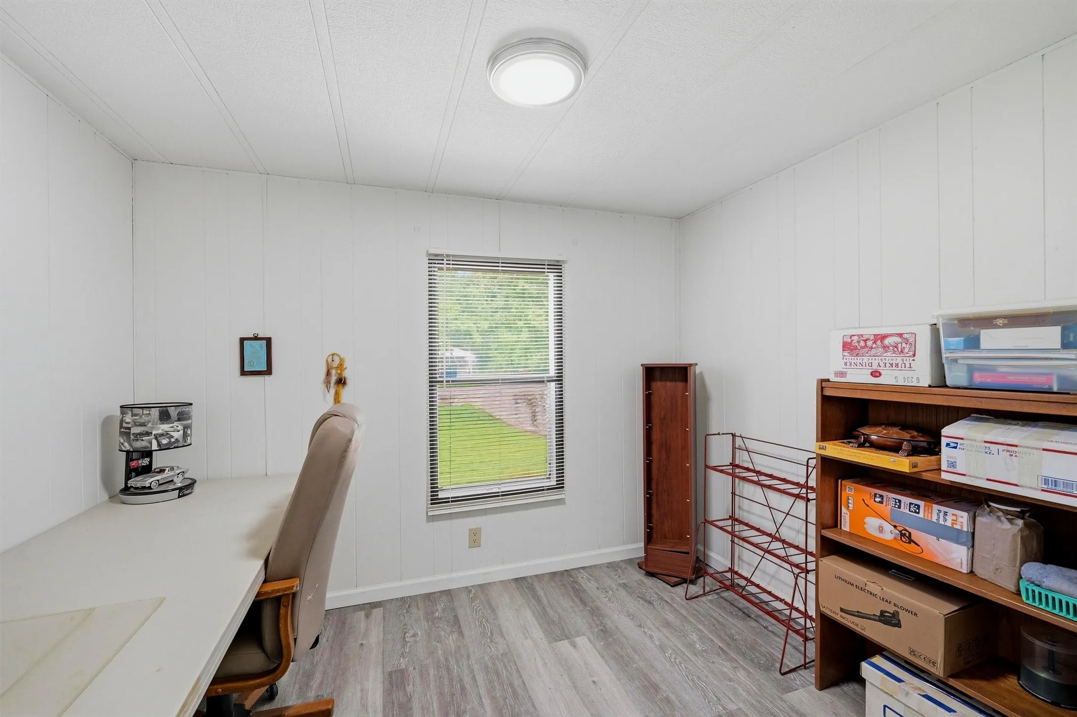 Interior room featuring wood-finish flooring and white vertical paneling