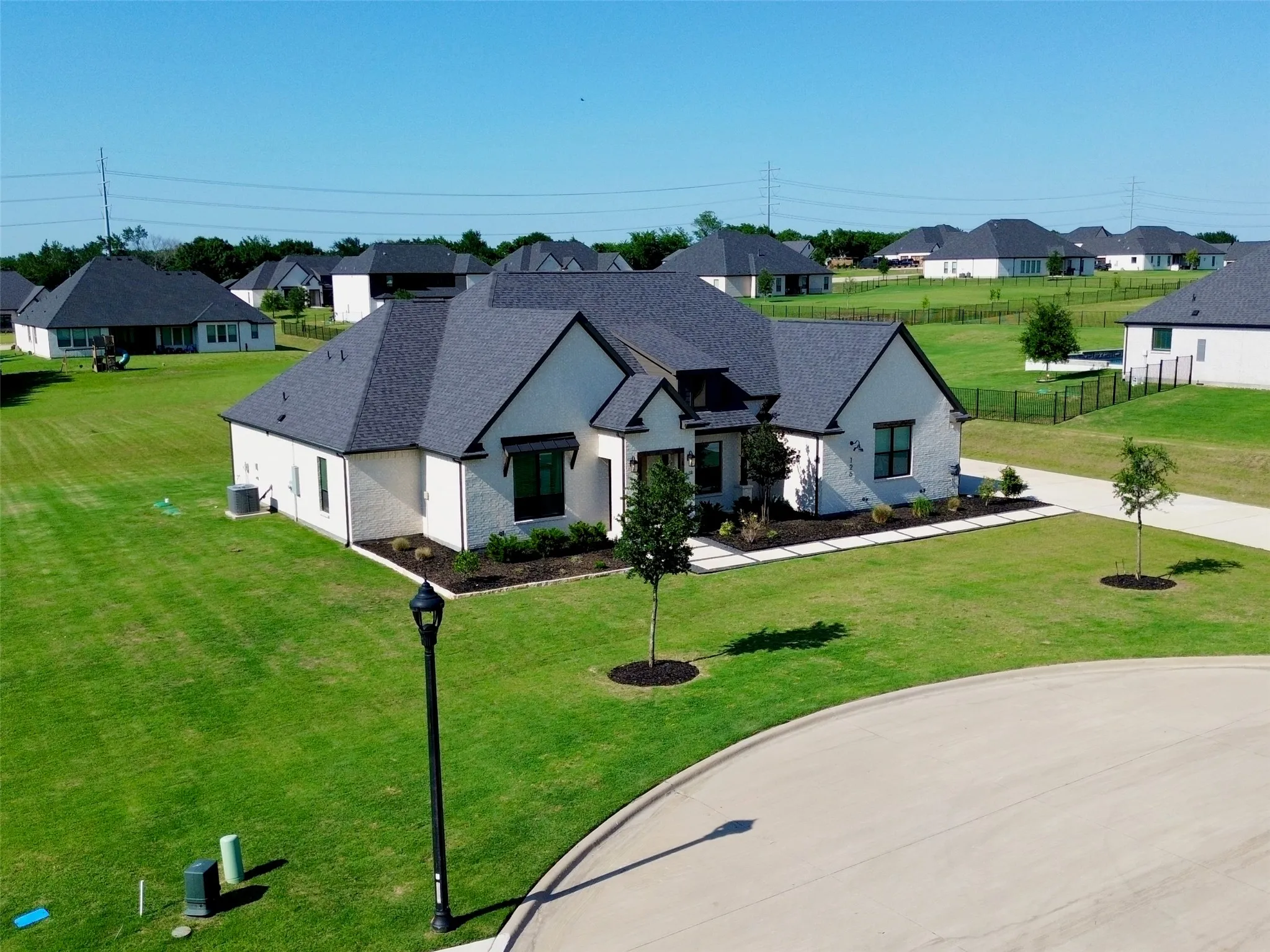 Contemporary white brick exterior with dark gray shingle roofing