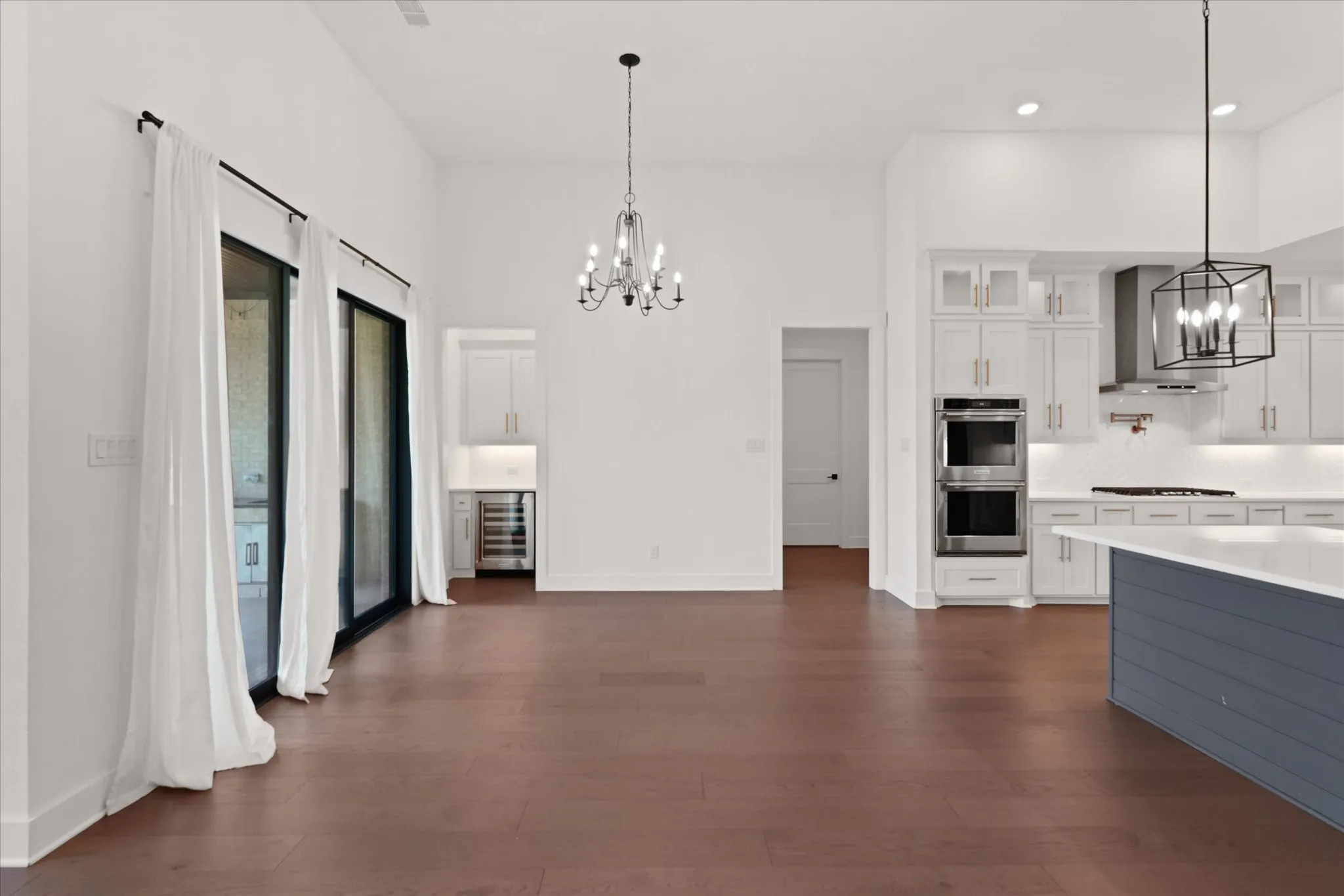 Spacious interior featuring high ceilings, dark wood-finish flooring, and large sliding glass doors