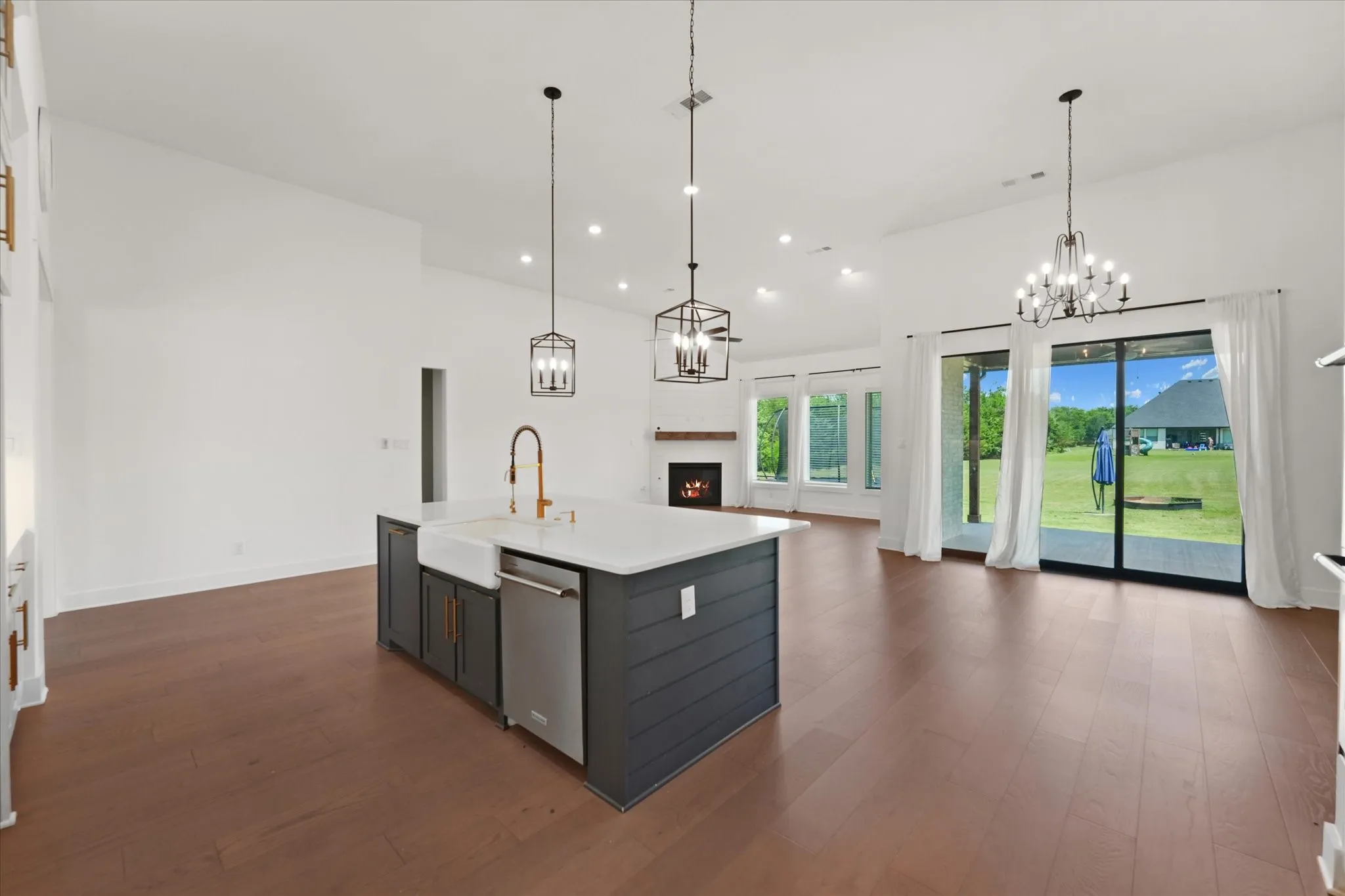 Spacious kitchen island with a farmhouse sink, stainless steel dishwasher, and a white countertop