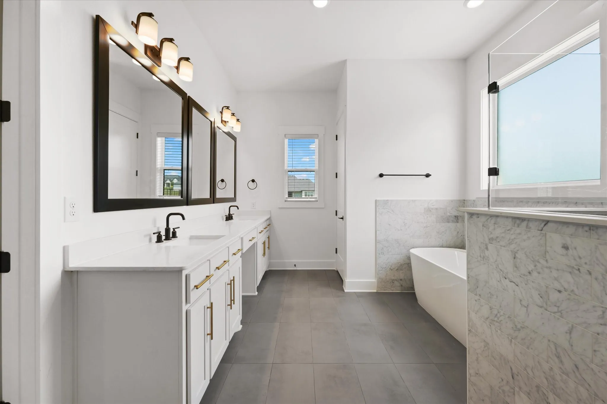 Dual vanity with white cabinetry, gold-tone hardware, and integrated sinks
