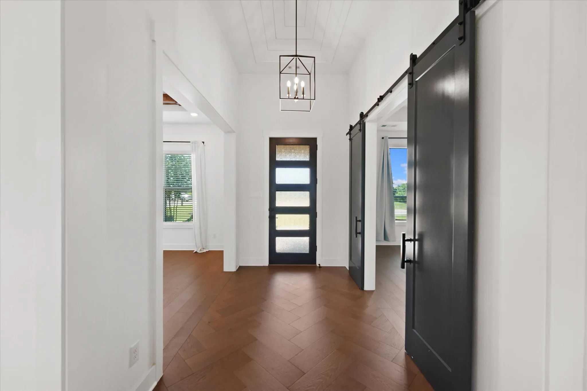 Entry foyer featuring wood-finish flooring in a herringbone pattern