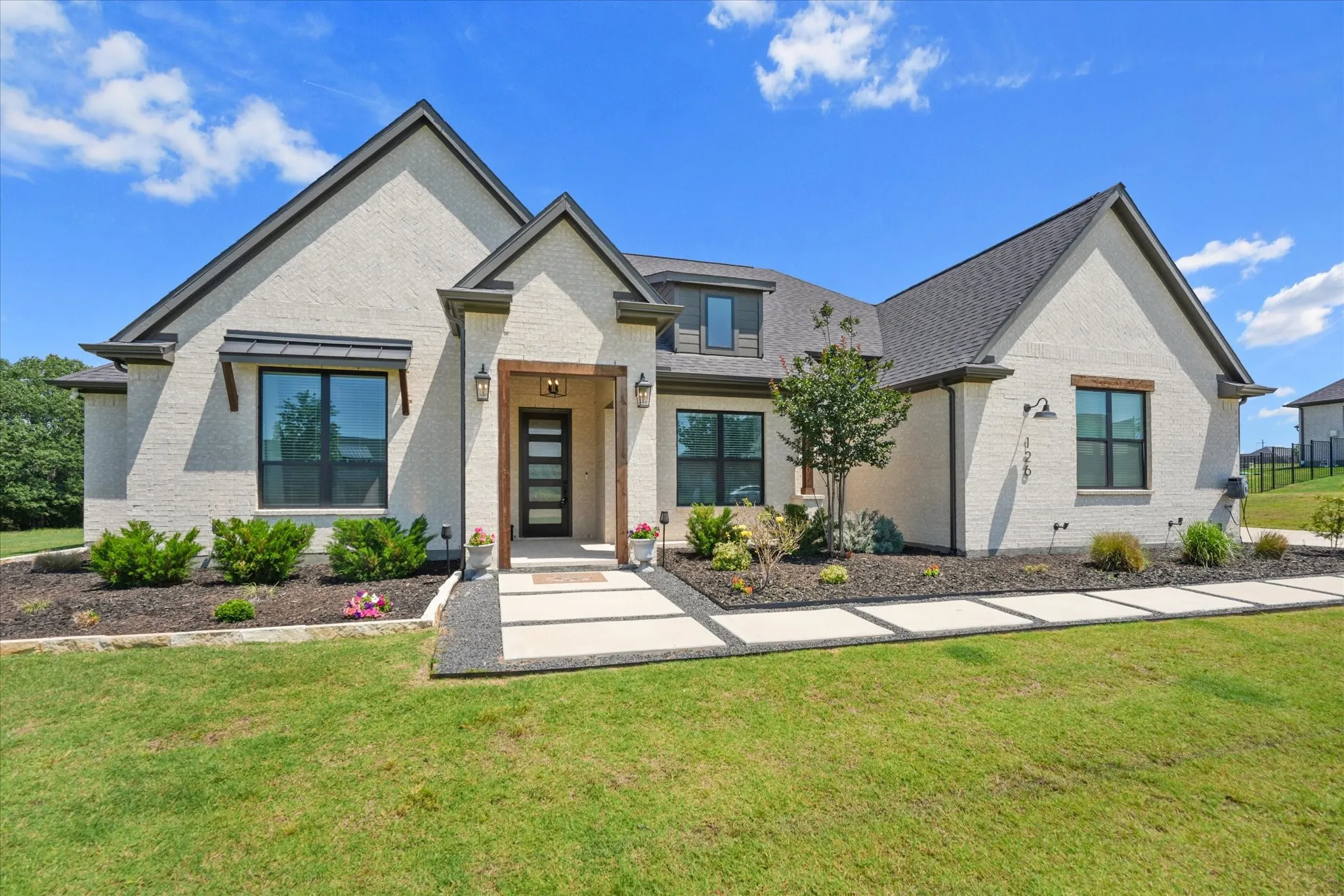 Modern exterior featuring a light-colored brick facade and dark trim accents