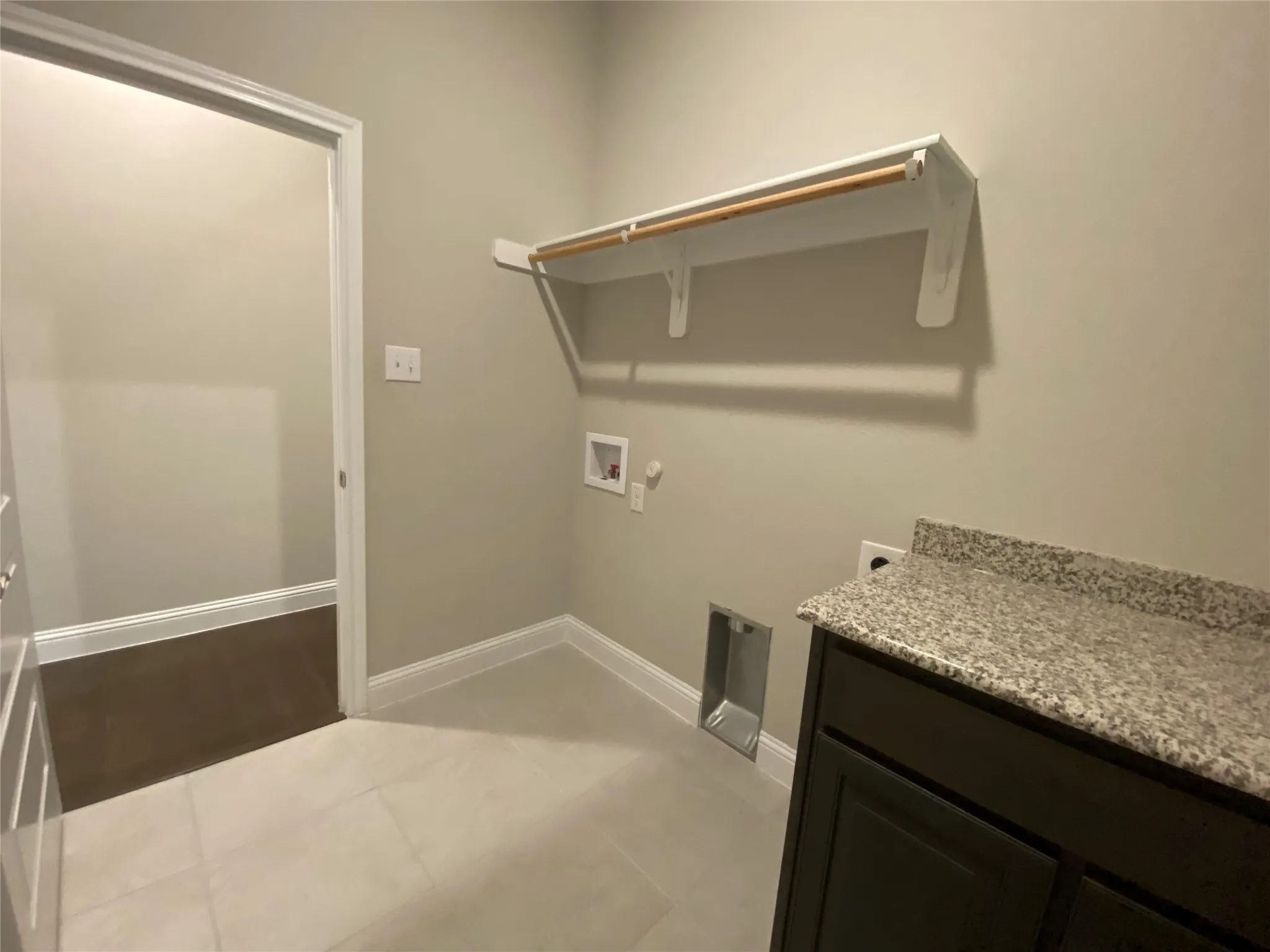 Laundry room featuring hookup for an electric dryer, tile flooring, and hookup for a washing machine