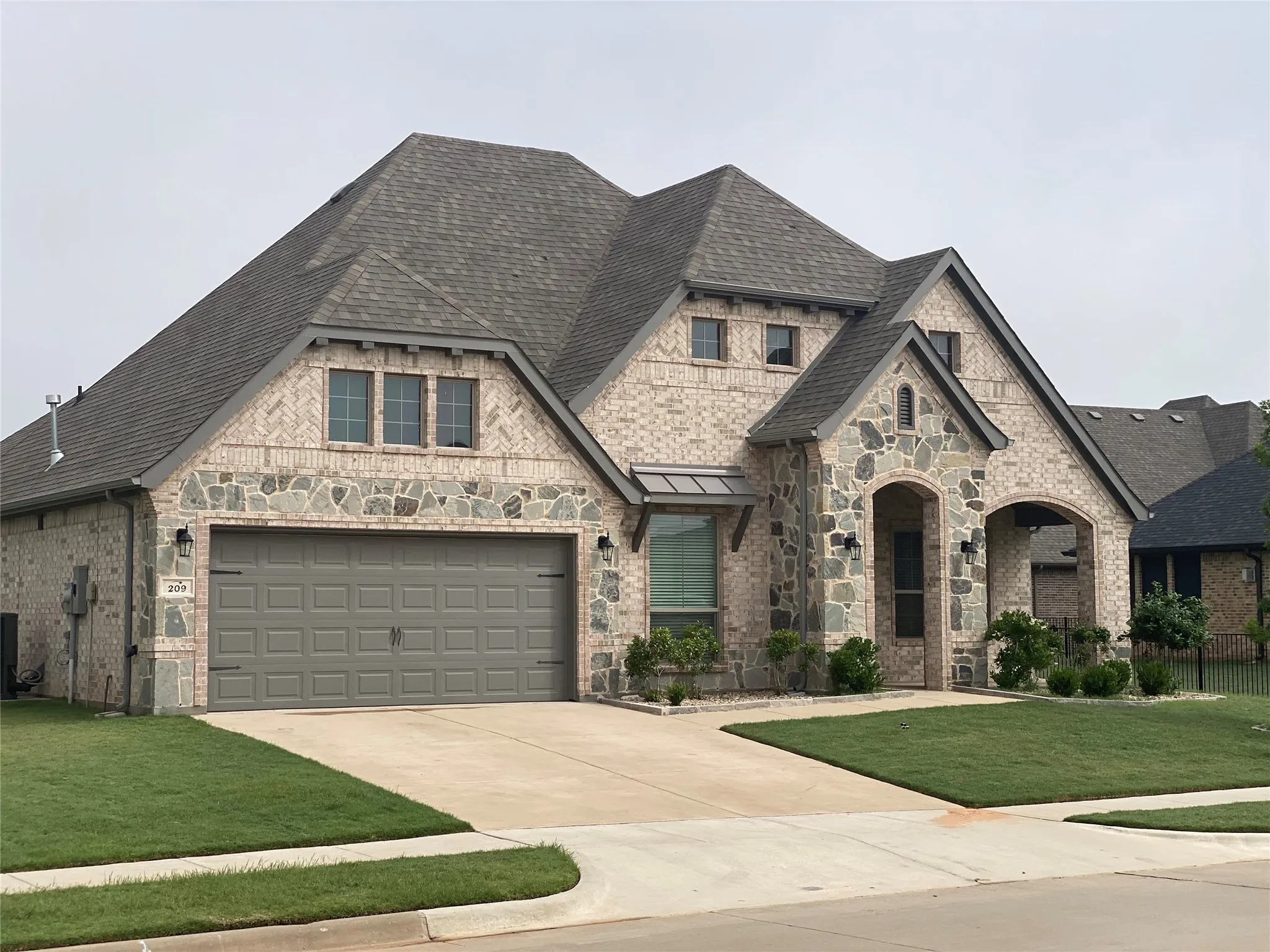 French provincial home featuring a garage and a front yard