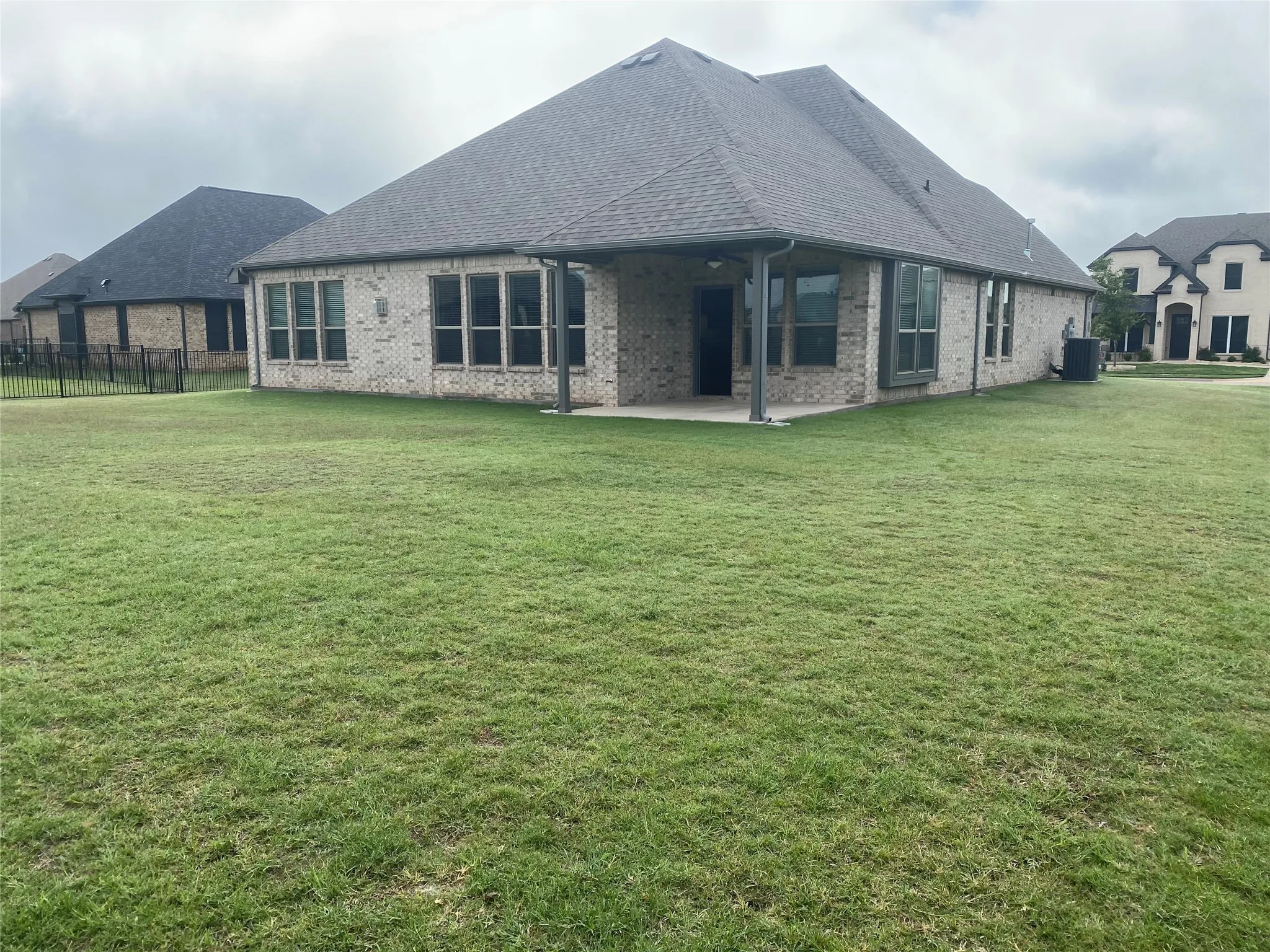 Rear view of house featuring a patio and a lawn