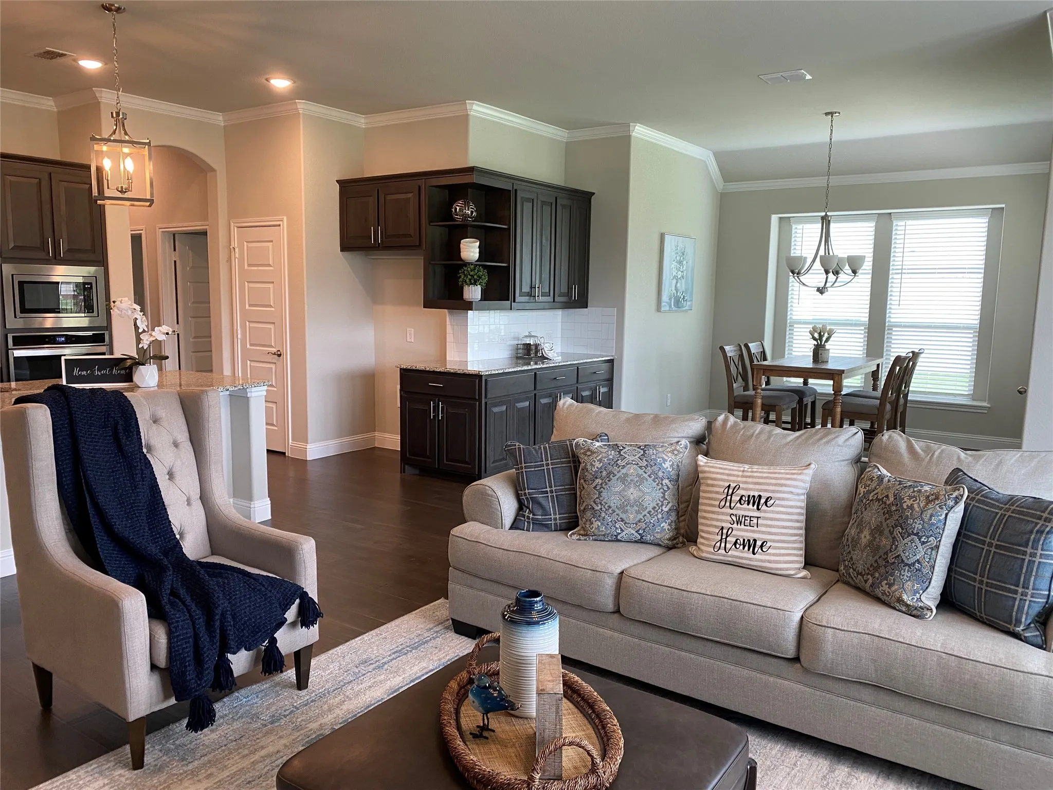 Living room with hardwood / wood-style floors, a notable chandelier, and crown molding