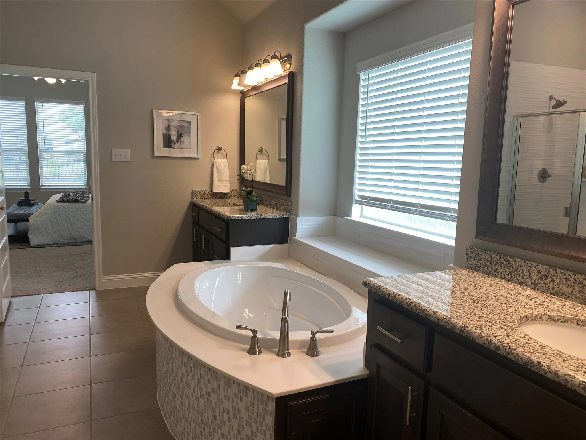 Bathroom featuring a healthy amount of sunlight, tile flooring, vanity, and separate shower and tub