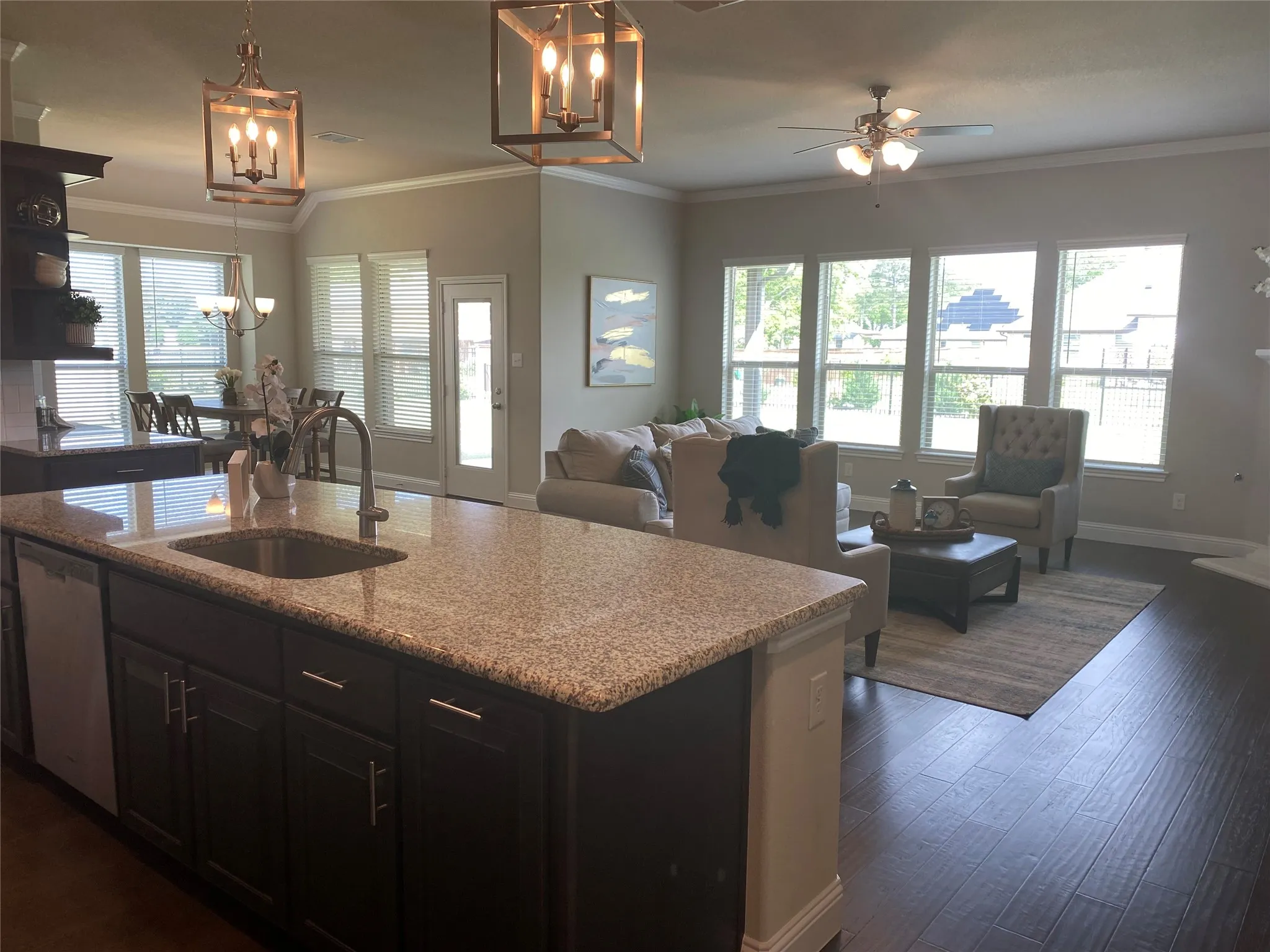 Kitchen featuring sink, dark hardwood / wood-style flooring, a kitchen island with sink, and crown molding
