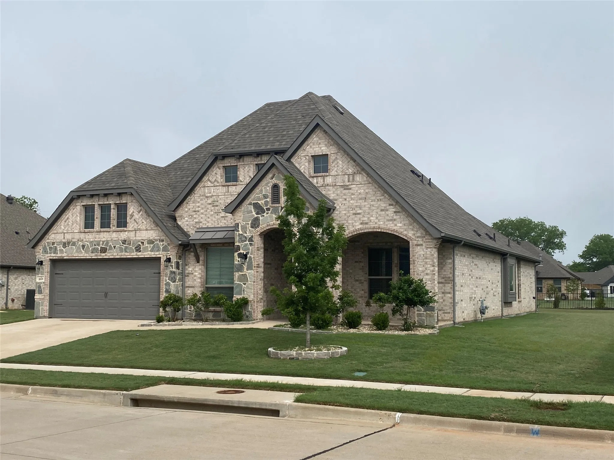 View of front of house featuring a garage and a front lawn