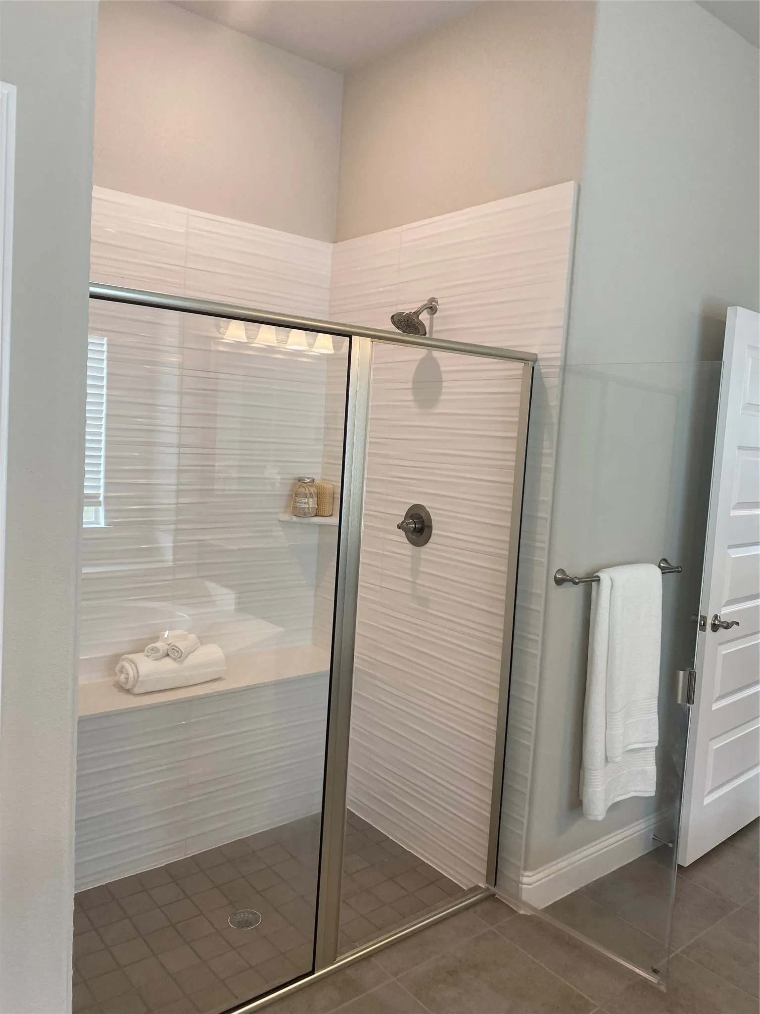 Bathroom with tile flooring and a shower with door