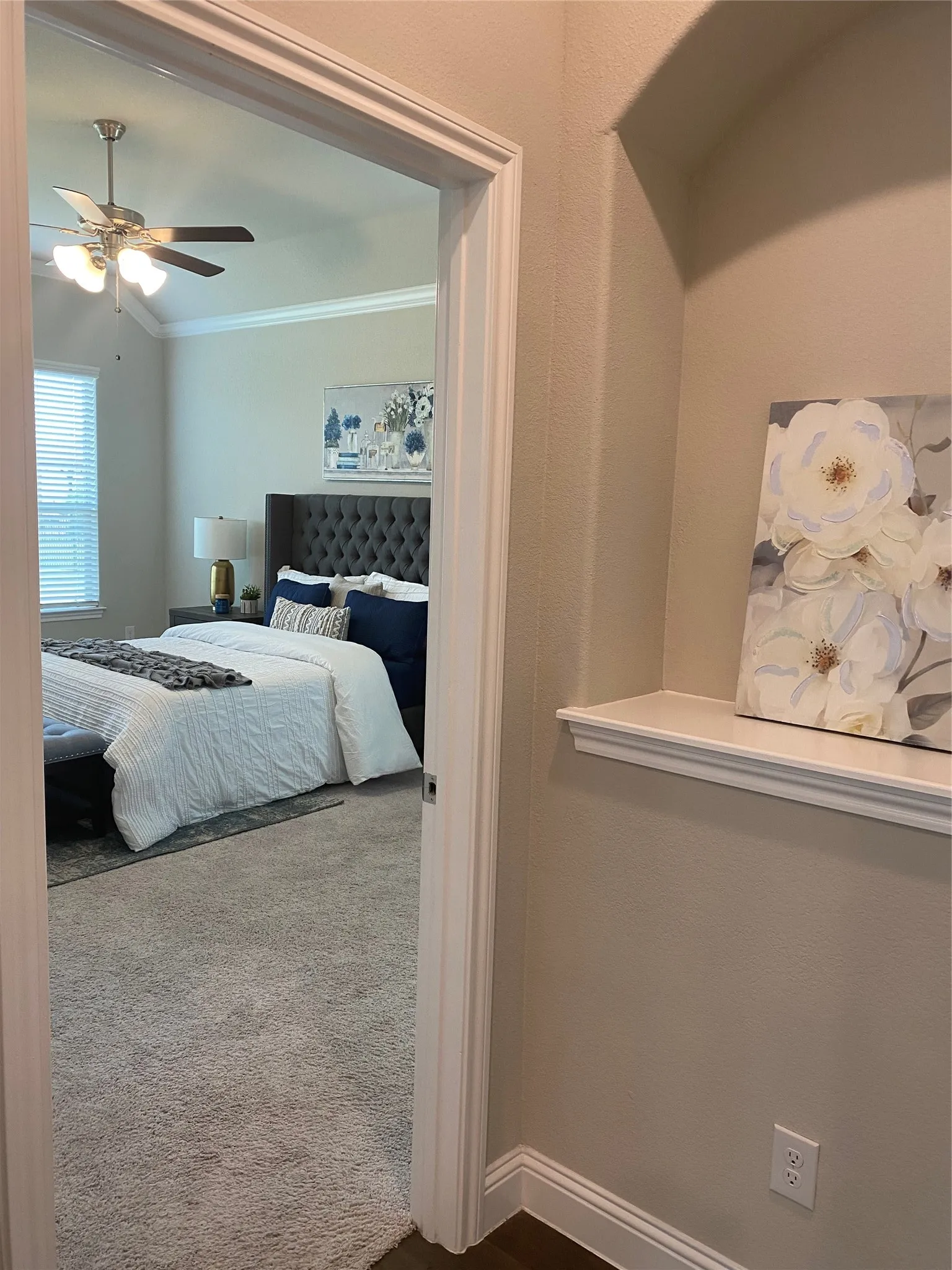 Bedroom with carpet floors, ceiling fan, and crown molding