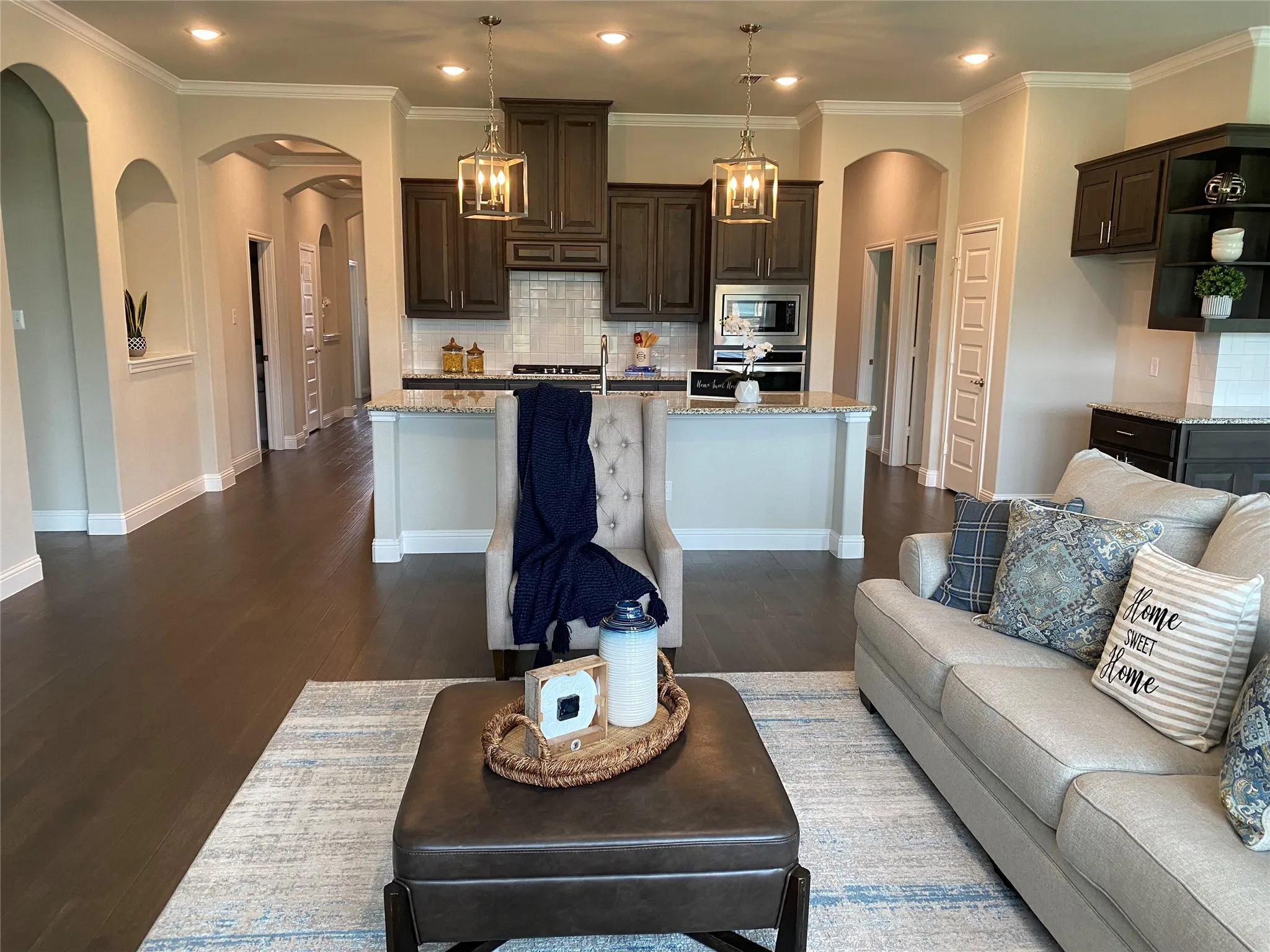 Living room featuring crown molding, dark wood-type flooring, and sink