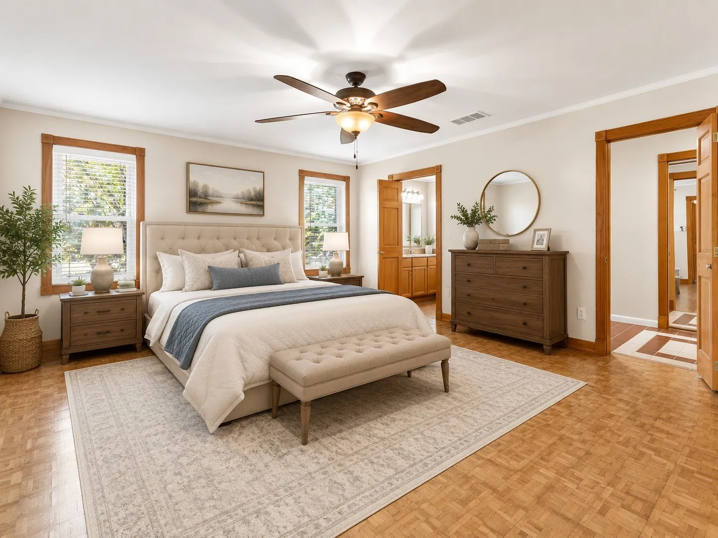 Virtually staged primary bedroom with ceiling fan and ensuite bathroom.
