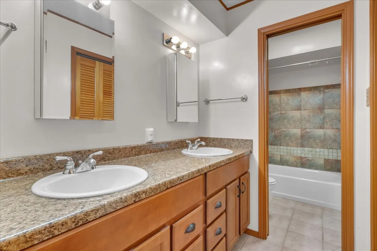 Guest bathroom with dual sinks, tub/shower combo, and two linen closets!